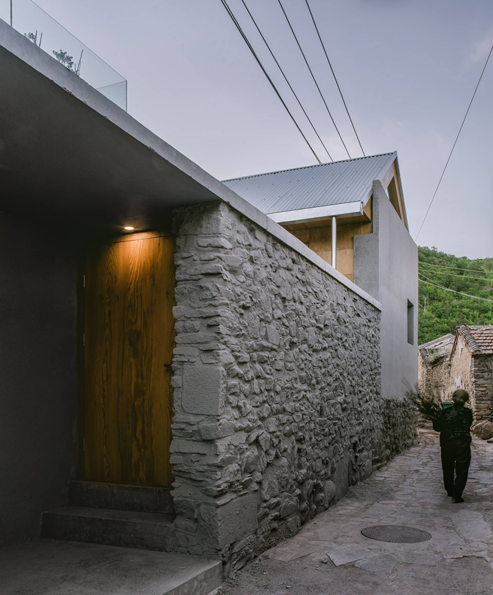 Modern building exterior featuring stone walls and a wooden door.