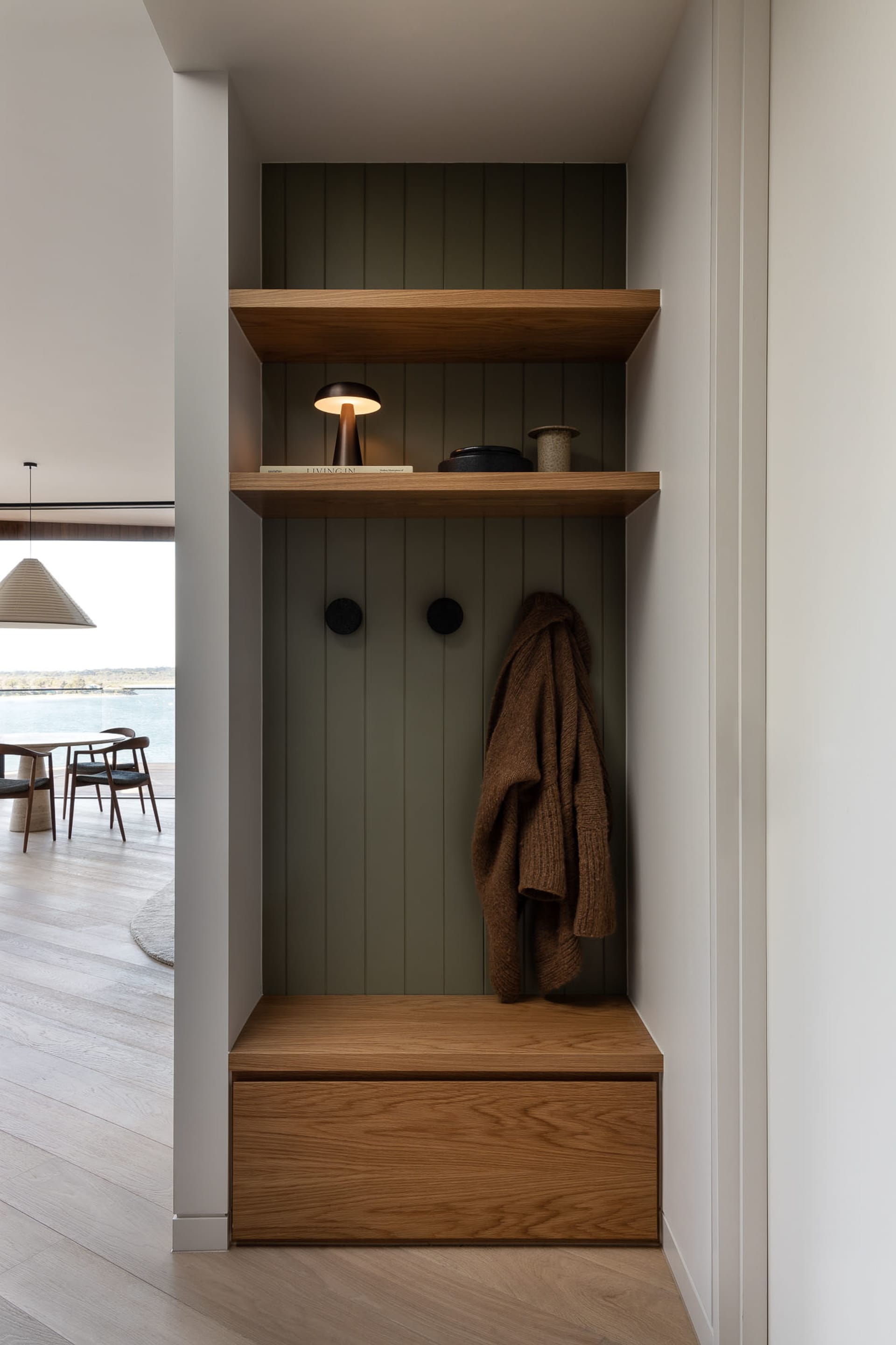 A modern entryway featuring a wooden shelving unit with metal accents.