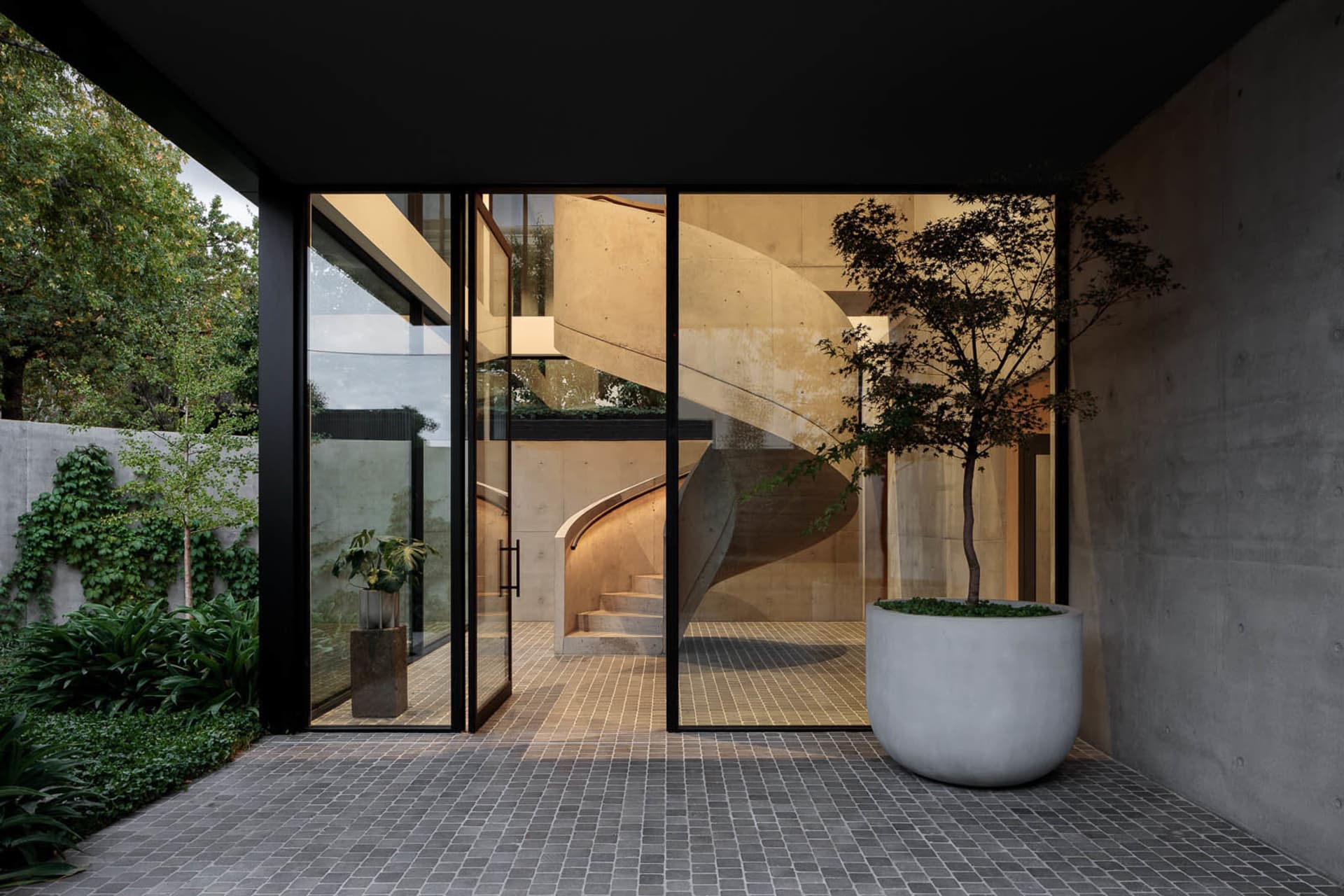 A modern industrial staircase with concrete steps and walls.