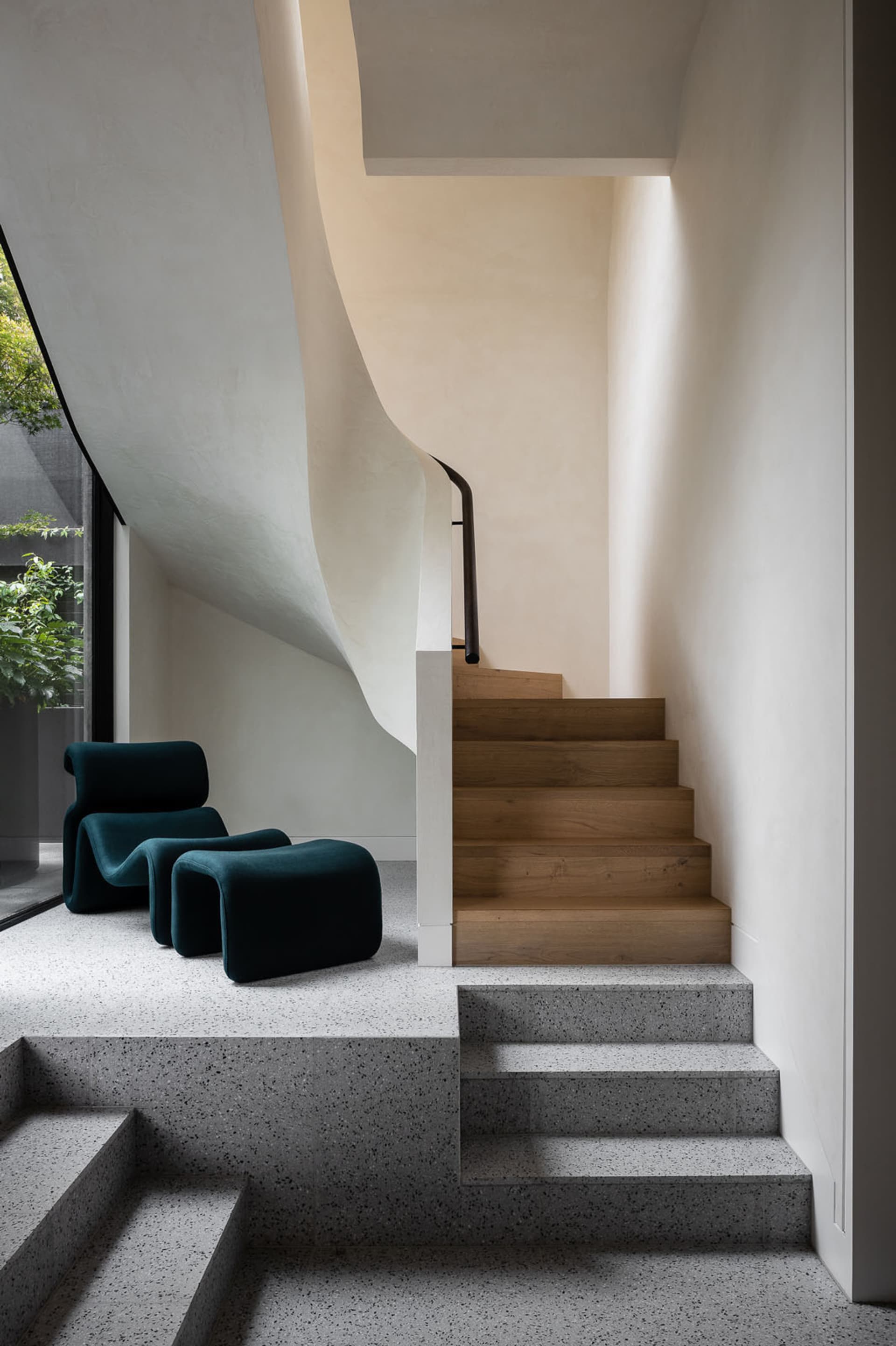 A modern concrete staircase with wooden steps in a minimalist interior design space.