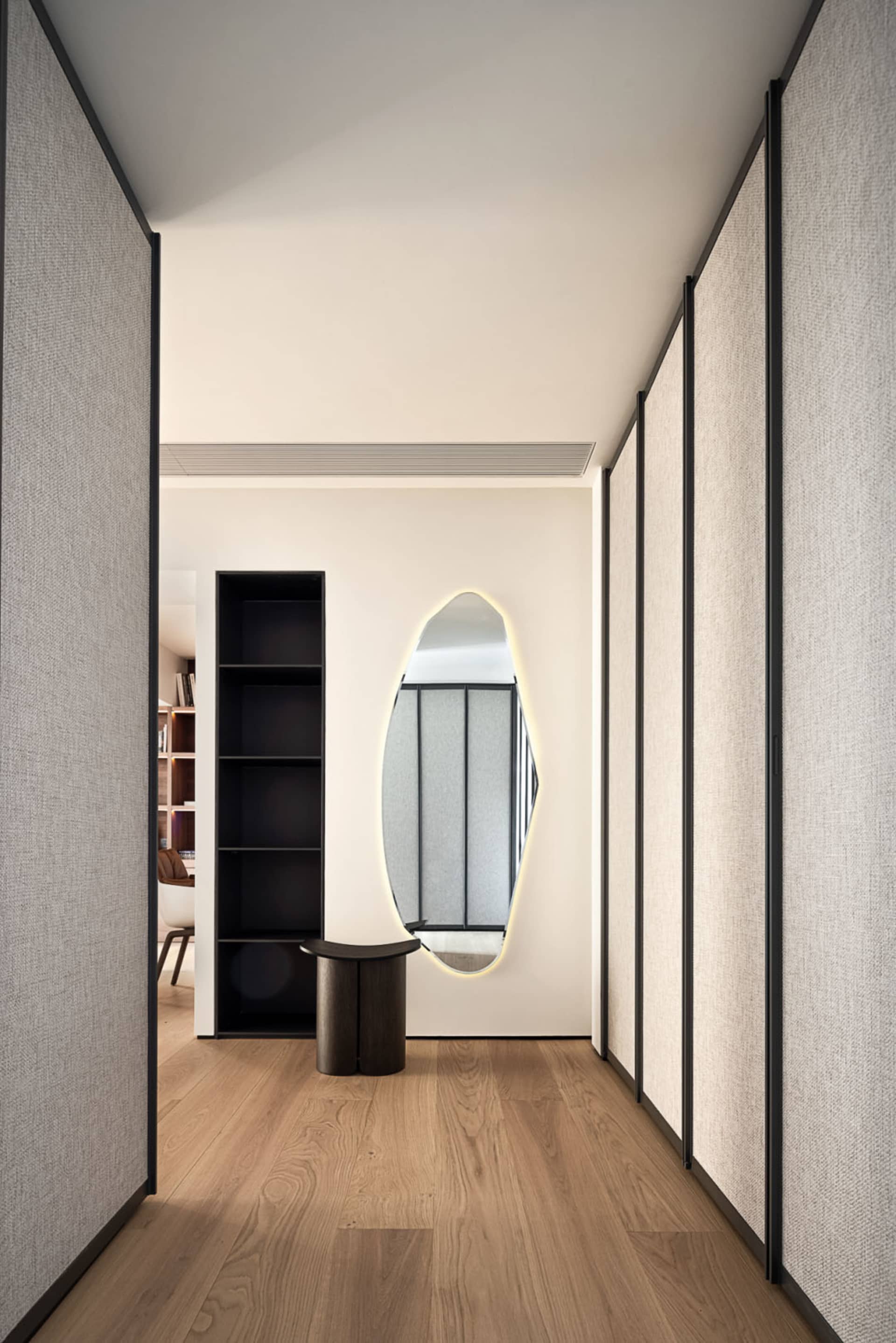 Modern hallway with textured wall panels and hardwood flooring