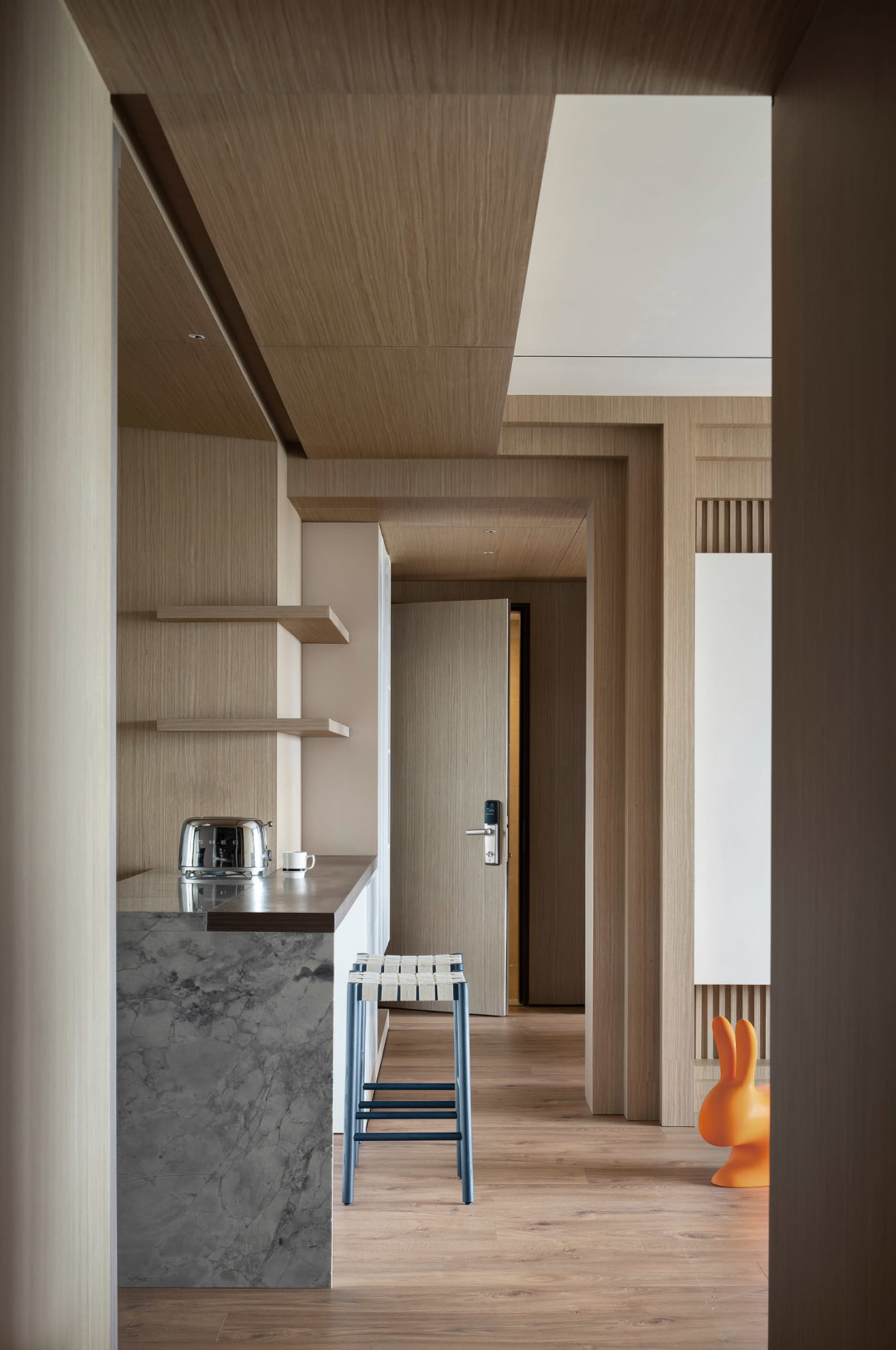 A modern residential kitchen with wooden finishes and a bar counter.