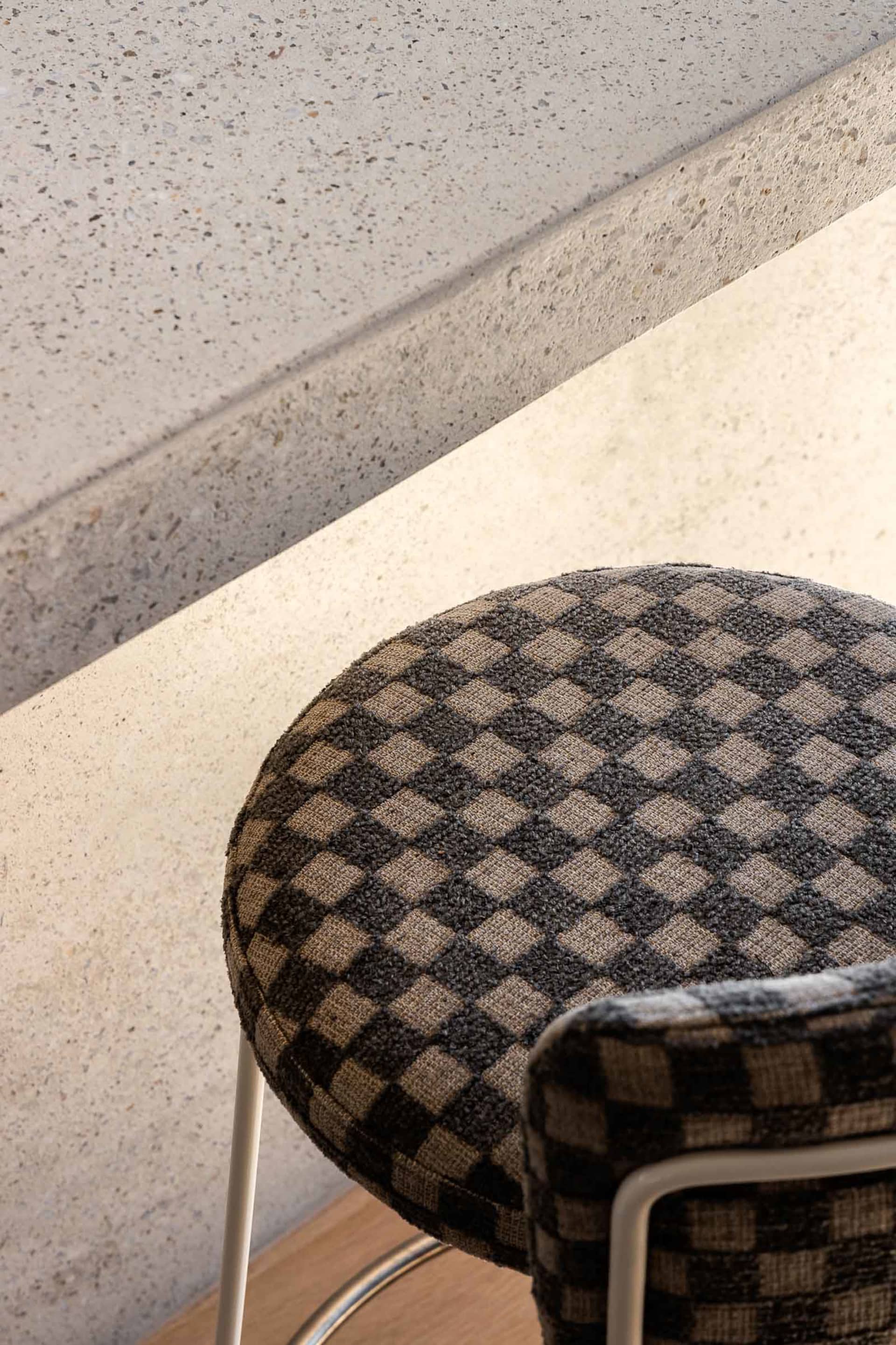 A modern chair with a checkered fabric upholstery, featuring a checked pattern.