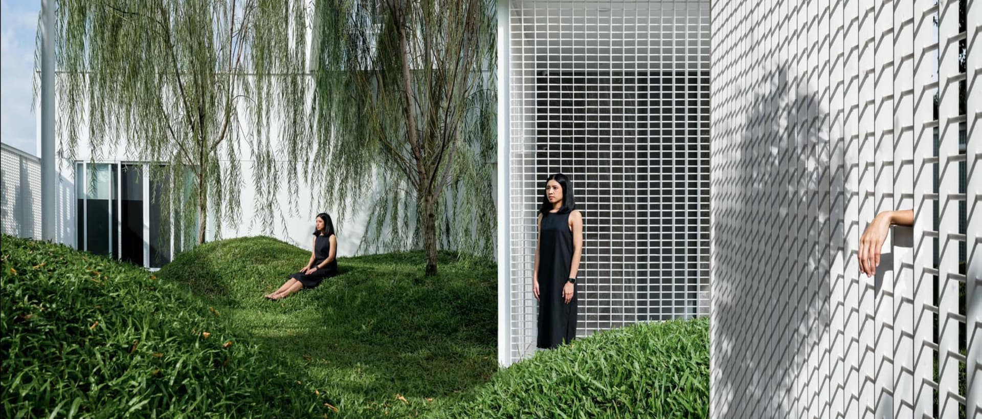 A modern outdoor space featuring concrete structures and lush green grass.