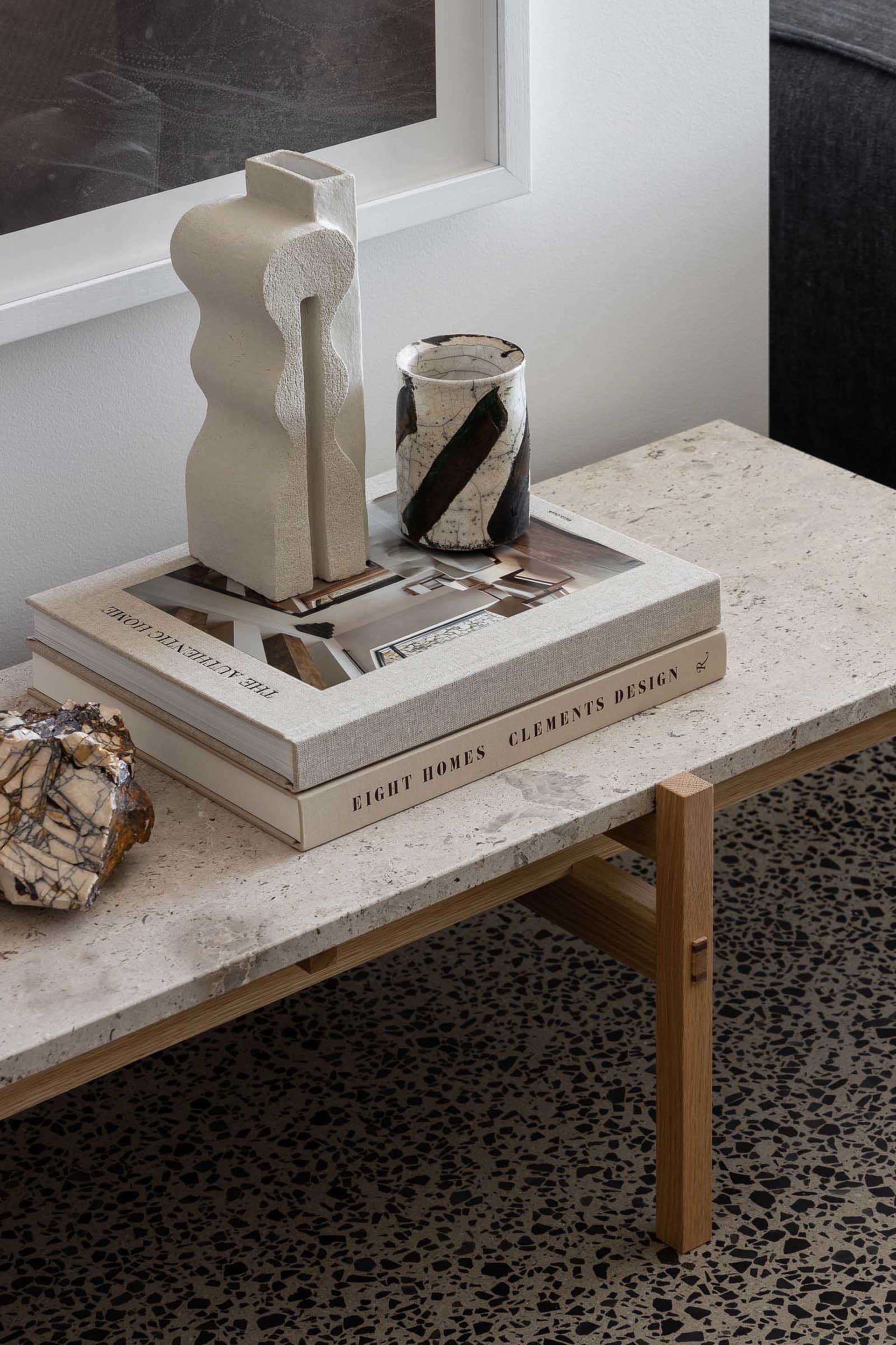 A coffee table made of marble featuring decorative ceramic objects.