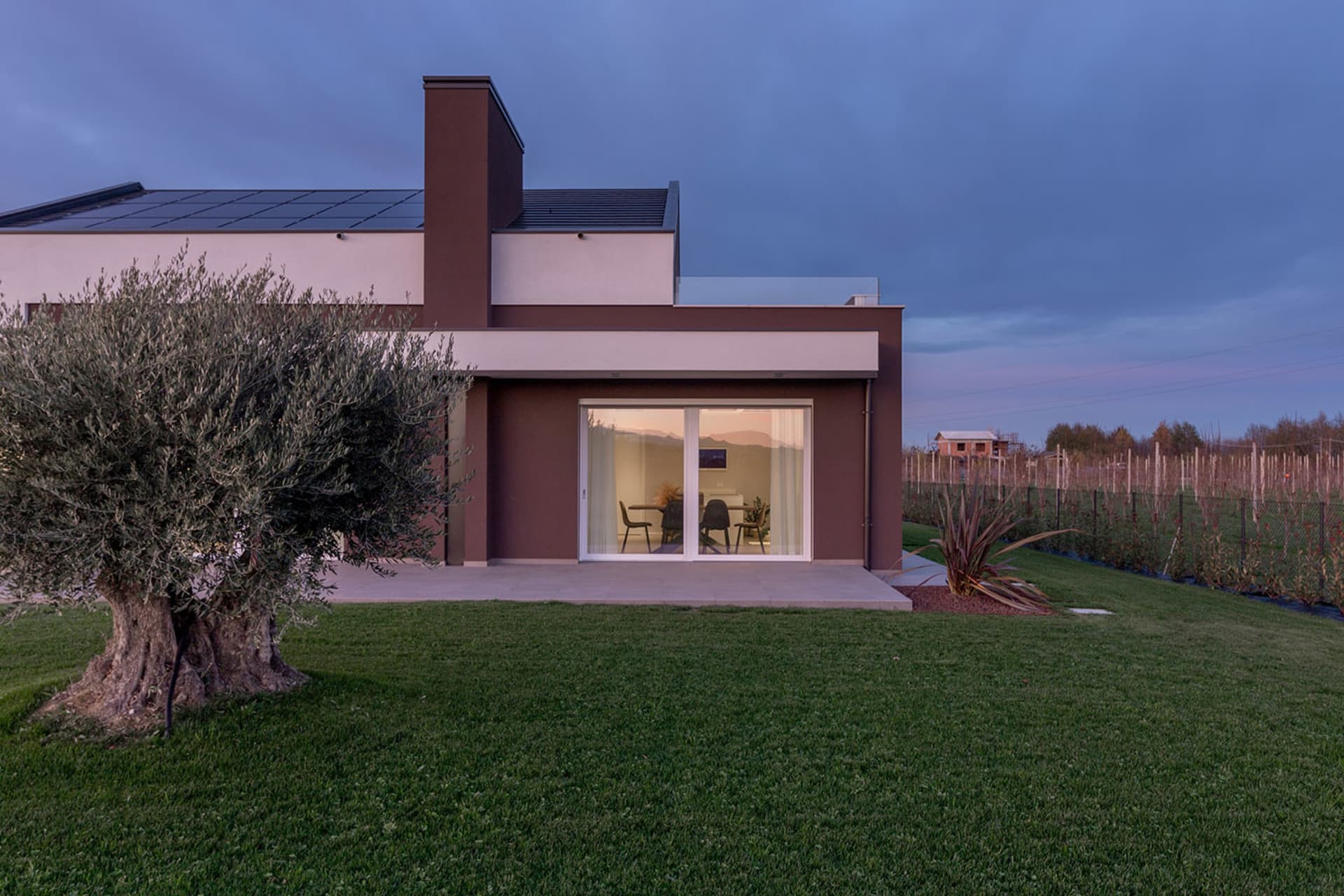 A modern residential exterior with minimalist design, featuring large windows and a sleek, contemporary style.