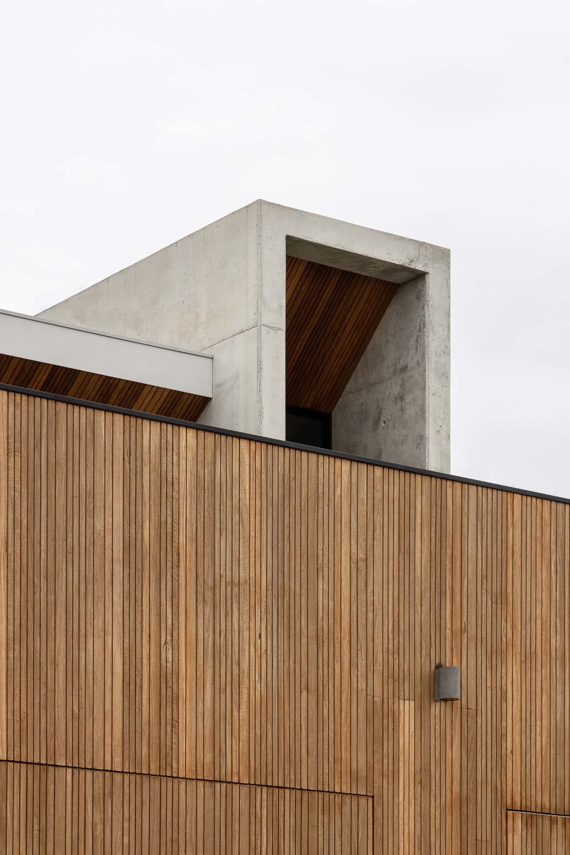 Modern building exterior featuring wooden cladding and concrete structural elements.