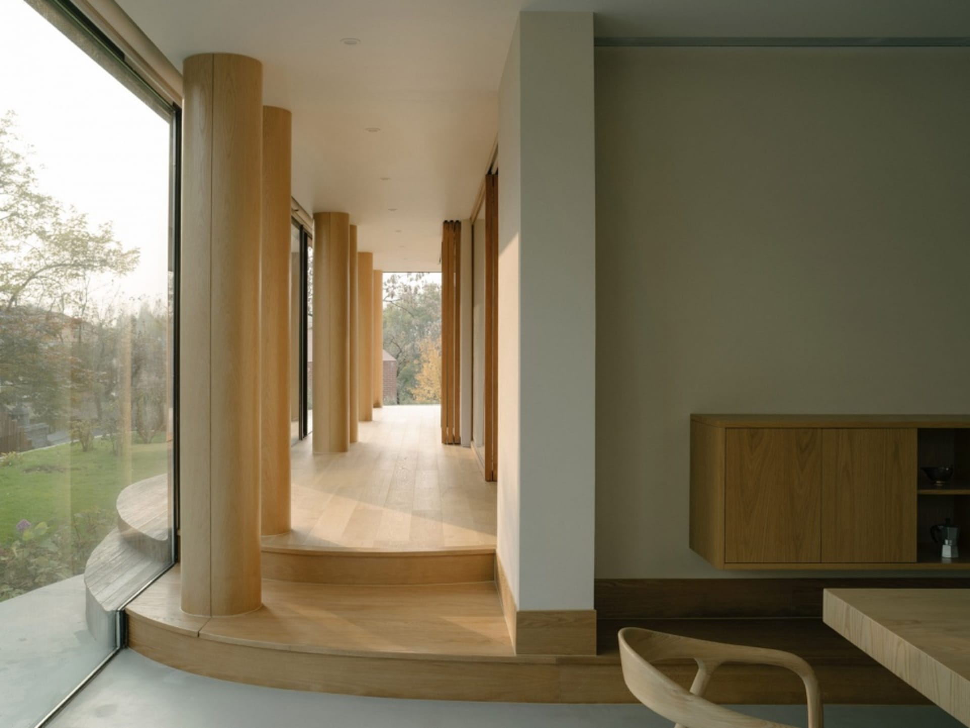 Modern interior with wooden columns and light-colored walls.