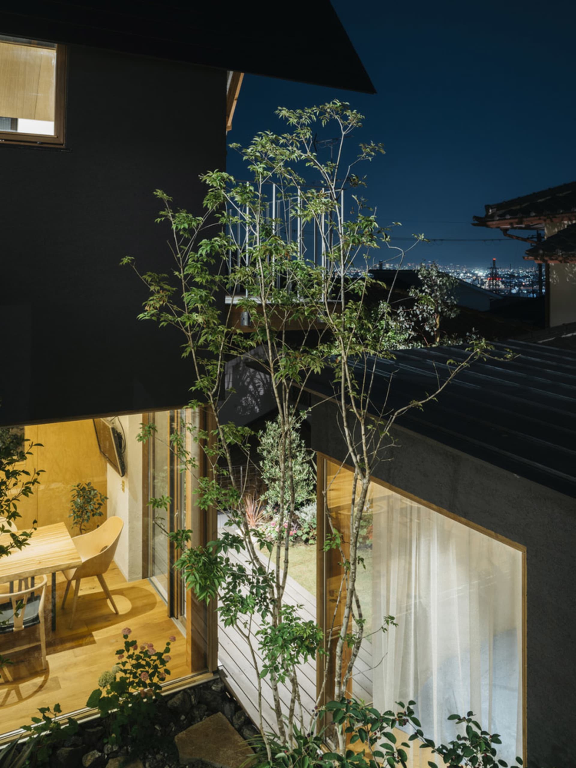 夜晚的現代住宅室內，展現木、玻璃與混凝土材質。