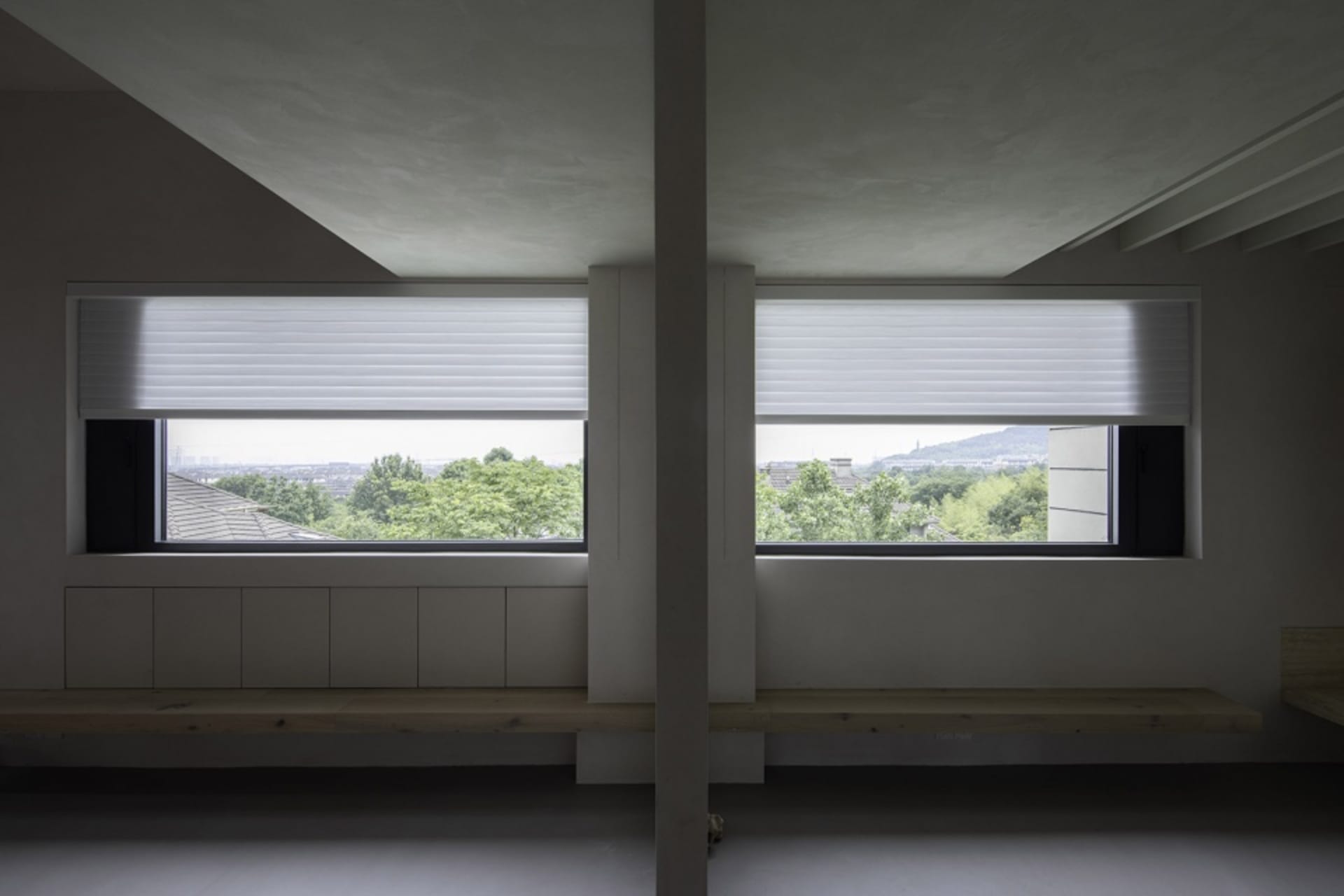 Modern architectural view with metal blinds covering large windows showcasing outdoor scenery.