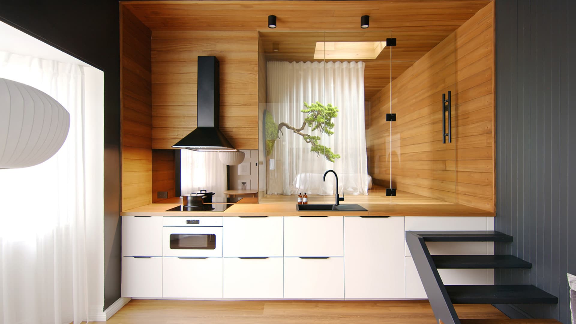 A modern, minimalist kitchen with wooden cabinets and a white color scheme.
