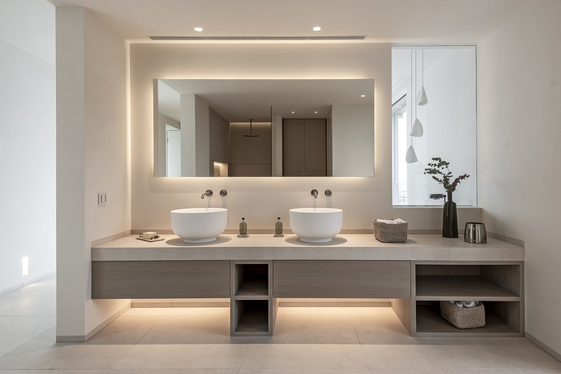 A minimalist bathroom with a double vanity and concrete finishes.