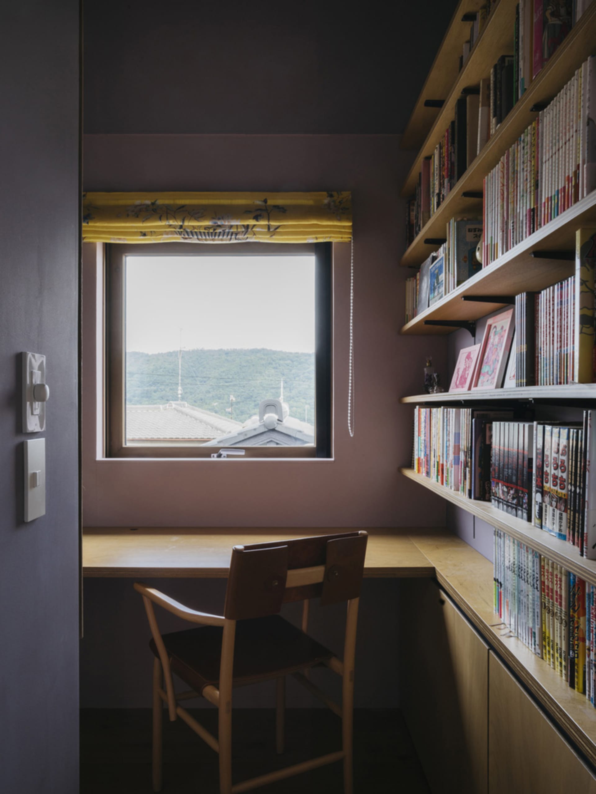 A minimalist bookshelf made of wood with books and shelves arranged neatly on shelves.