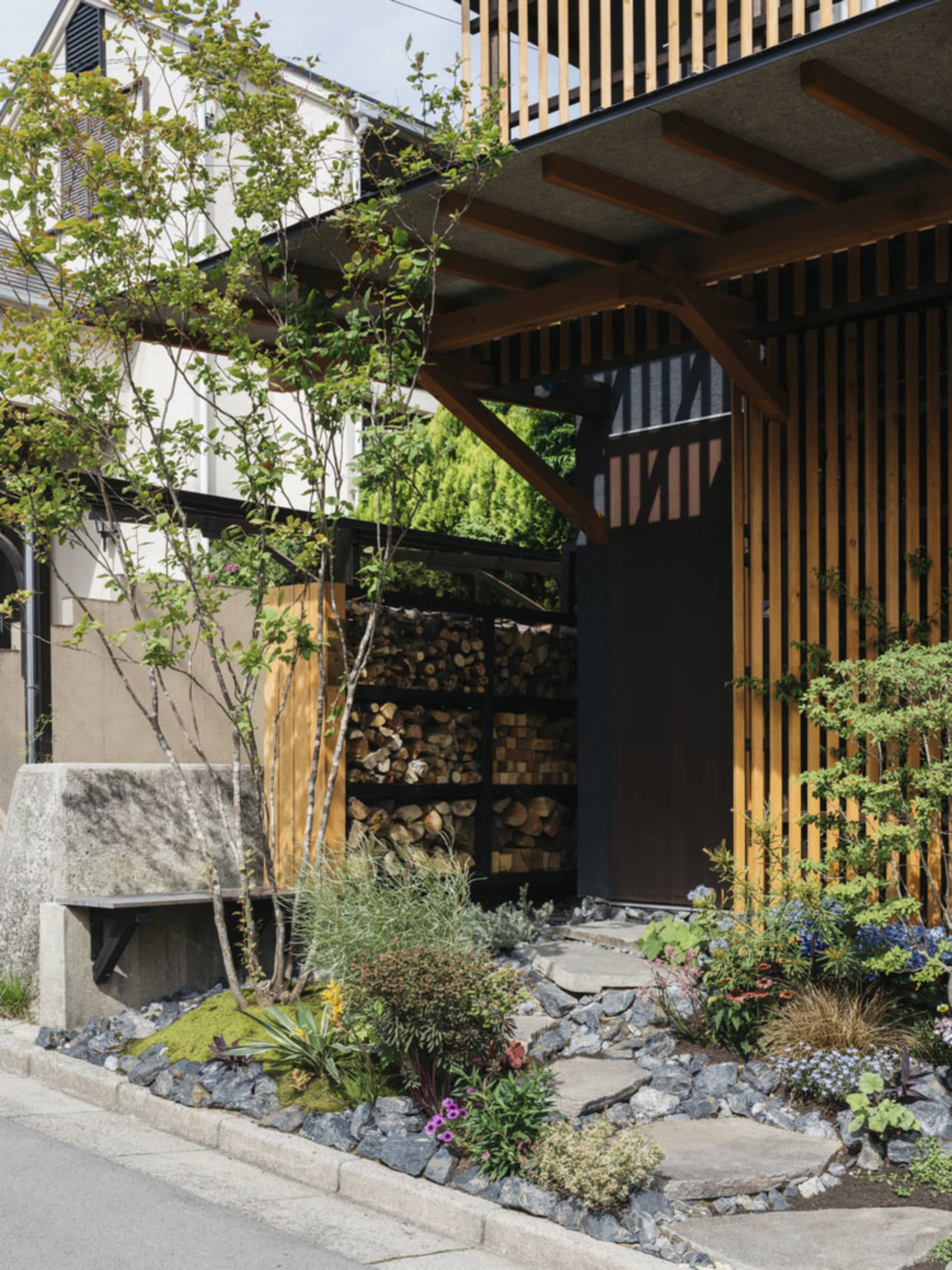 Modern residential entrance featuring wood, stone, and concrete materials.