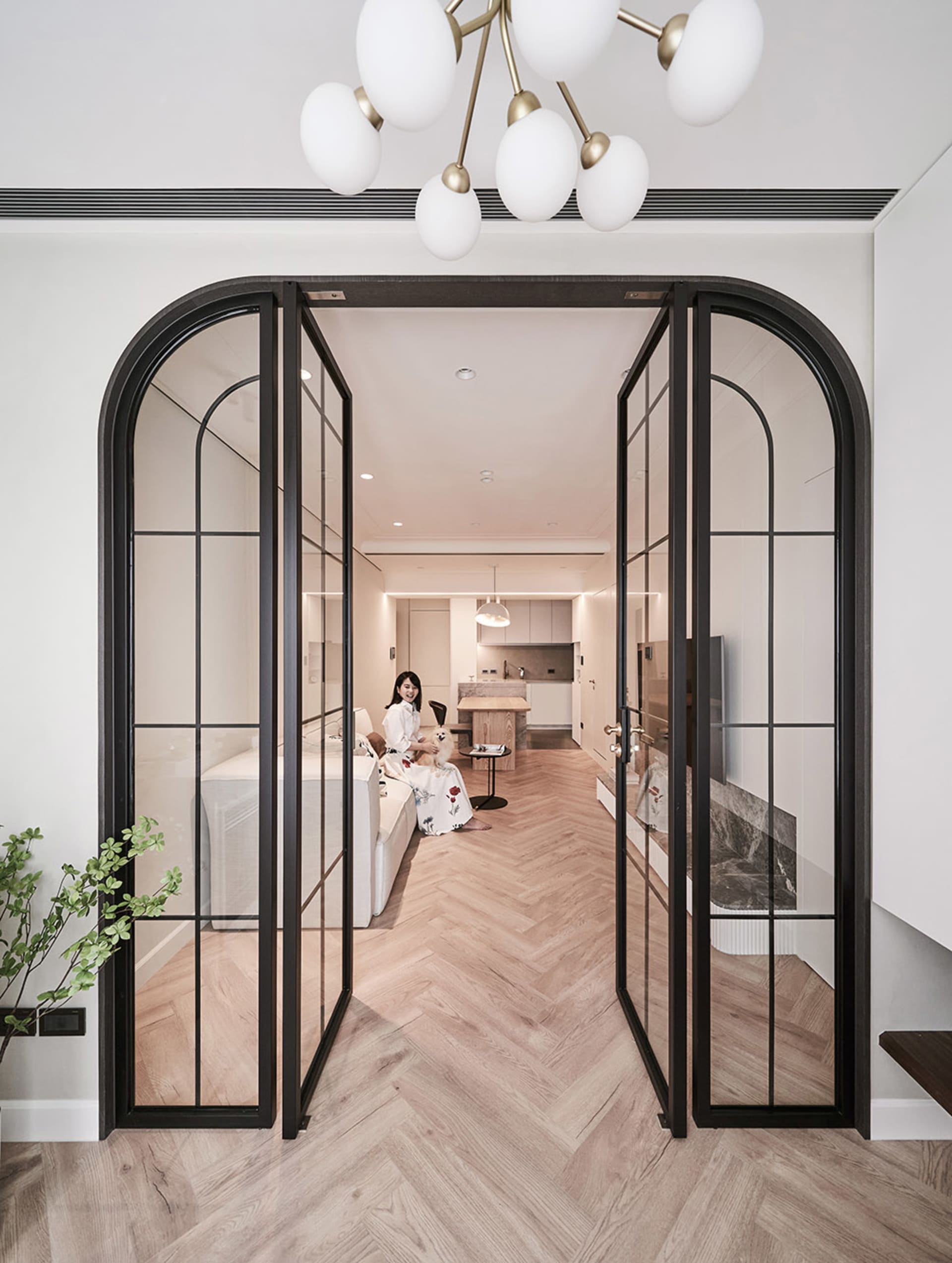 A minimalist living room with wooden furniture and glass doors.