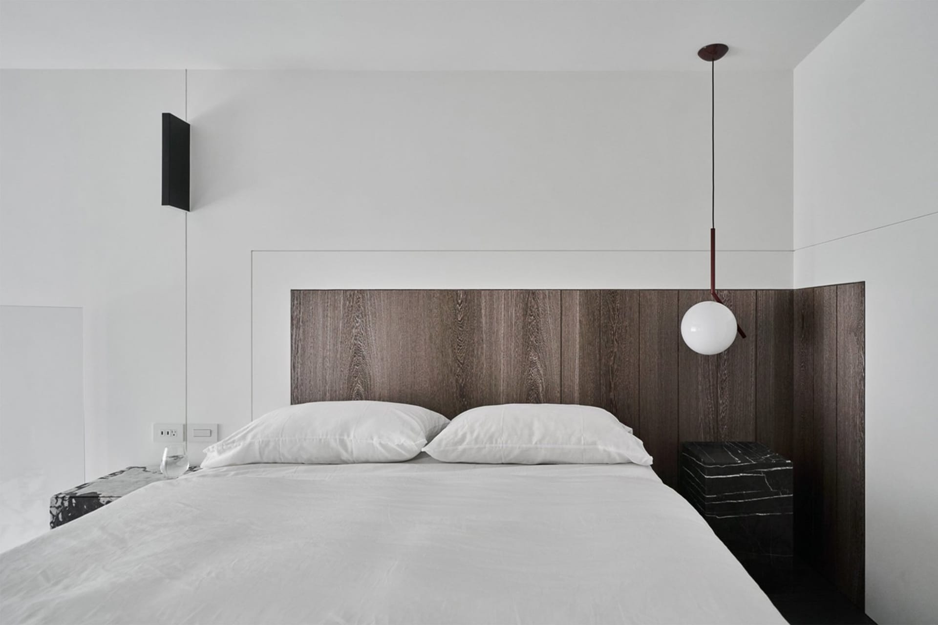 A modern bedroom featuring a wooden headboard with white bedding and pillows.