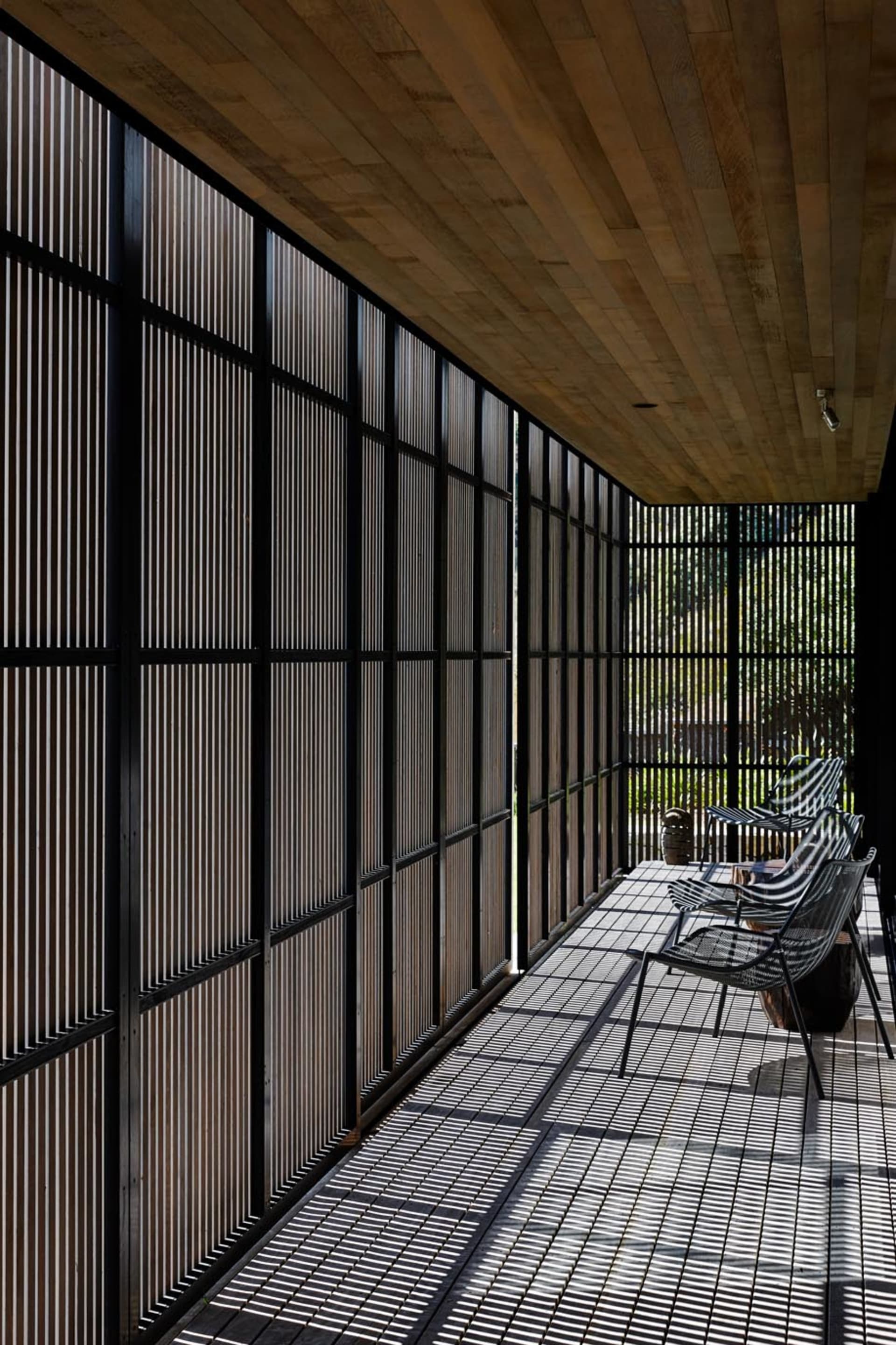A modern patio with wooden grid panels and a wooden ceiling.