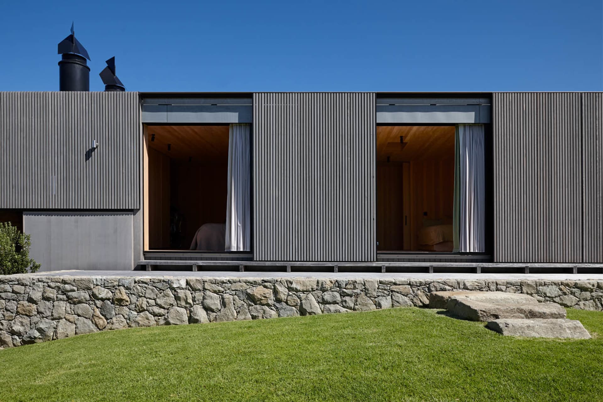 Modern residential house featuring a contemporary design with metal cladding exterior and large windows.