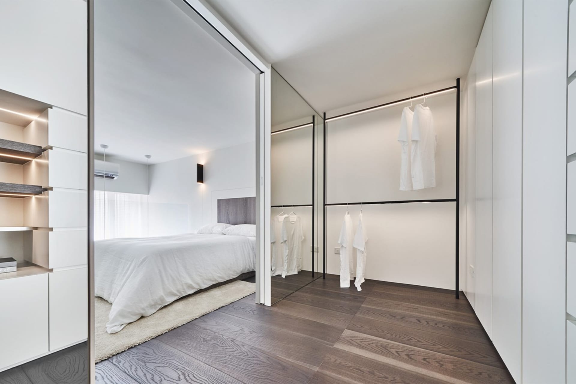 Modern bathroom with white walls, wood flooring, and minimalist design.