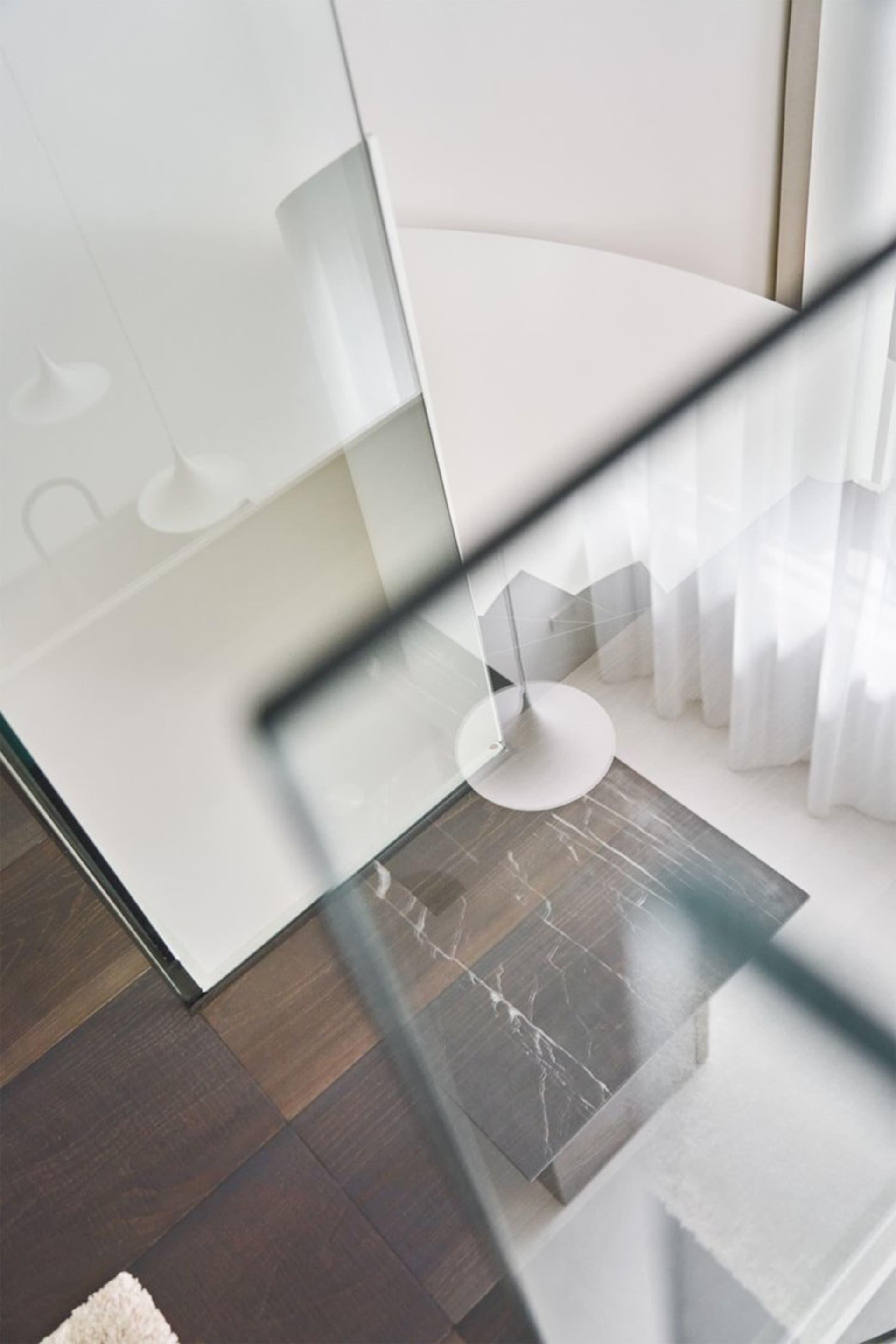 A modern interior design featuring a glass floor with a dark wood grain pattern.