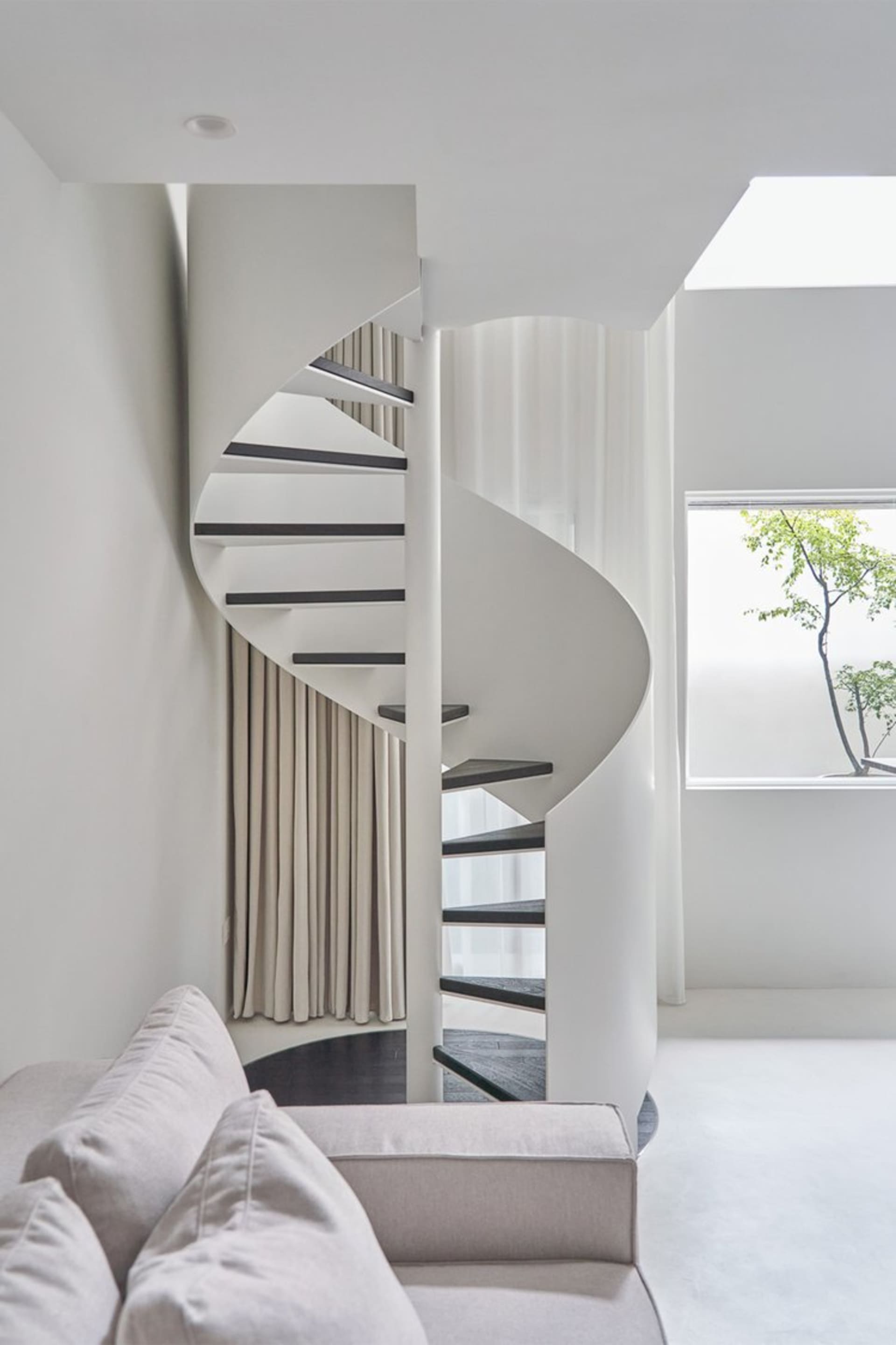 A minimalist-style staircase featuring a concrete structure and glass railings.