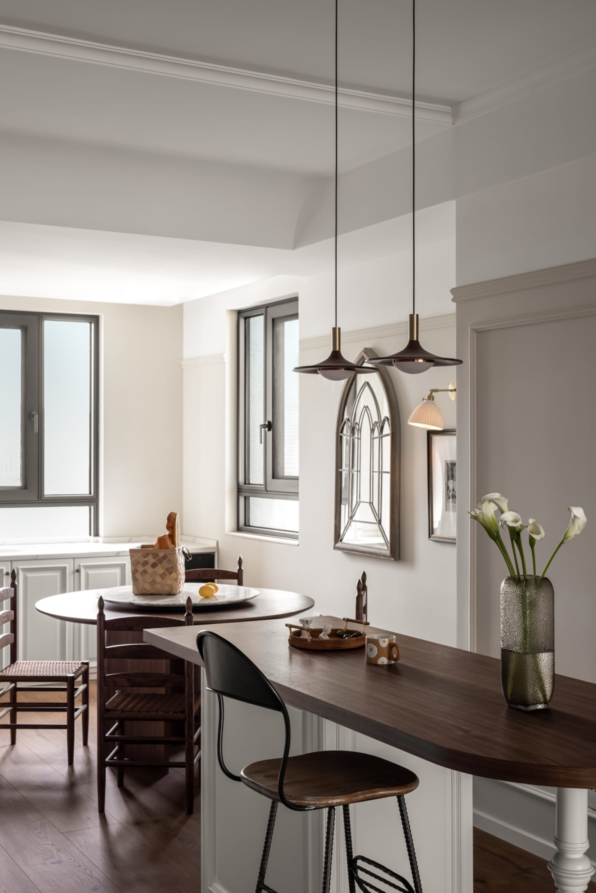 A modern rustic kitchen featuring wooden counters and island, glass cabinet doors, and metal accents