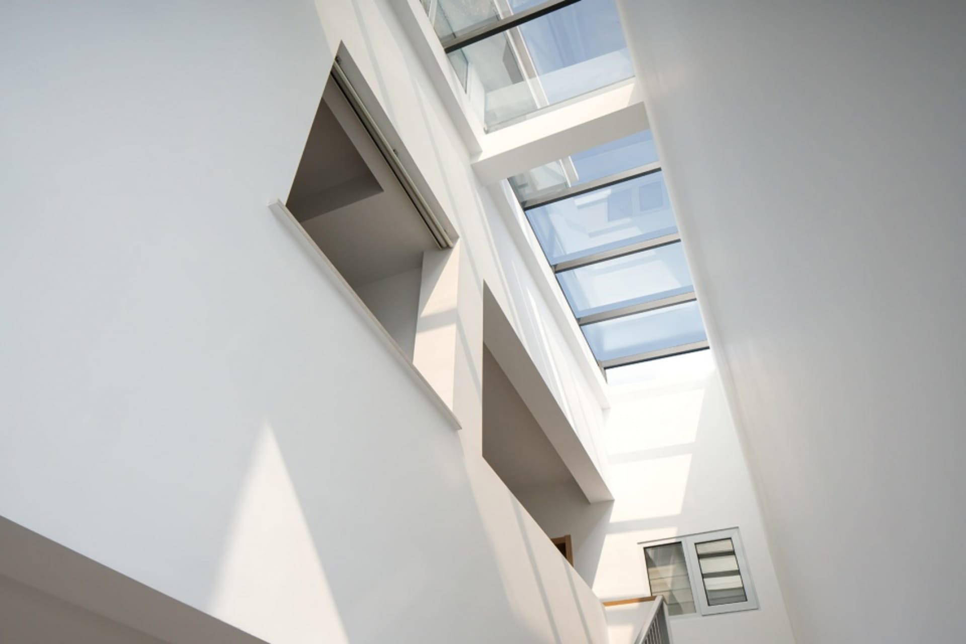 Modern, minimalist space featuring large glass skylights providing natural light.