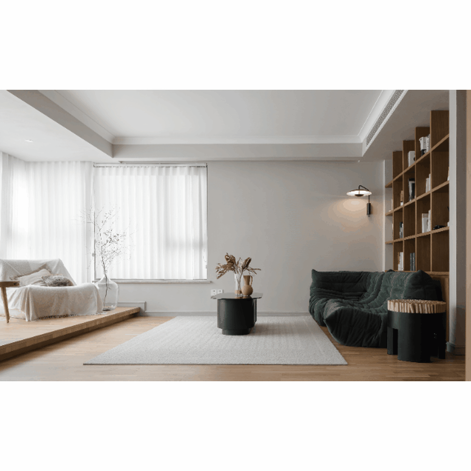 Modern living room with white interiors, minimalistic furniture, and a cozy atmosphere featuring a green sofa and a wooden bo