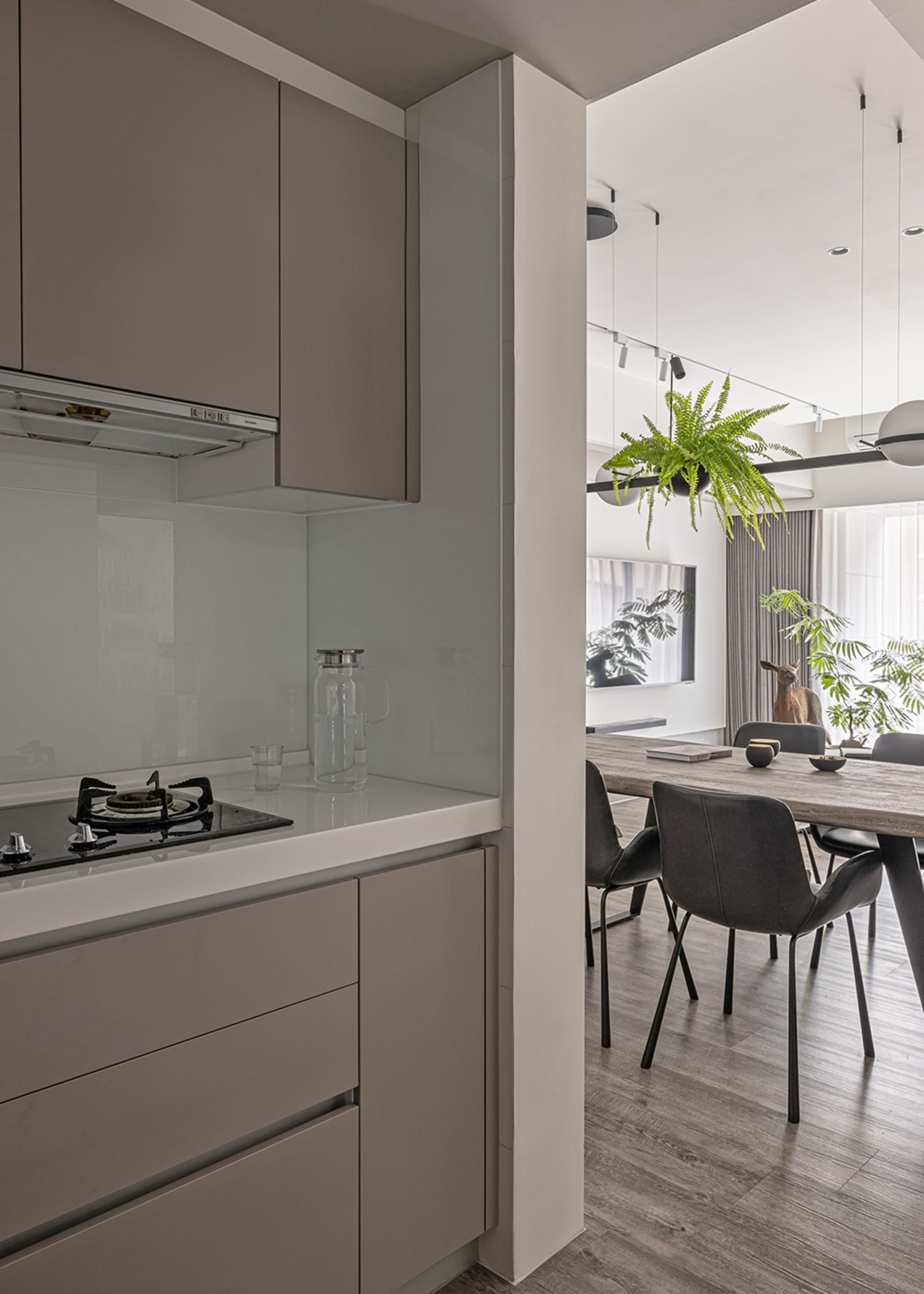 Kitchen with minimalist design, neutral tones, and glass backsplash.