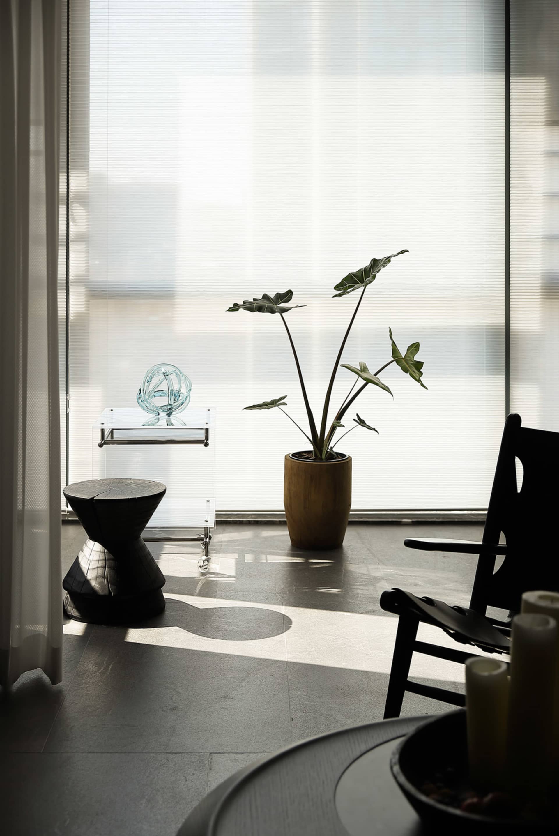 A minimalist living room featuring a glass planter with ceramic accents.