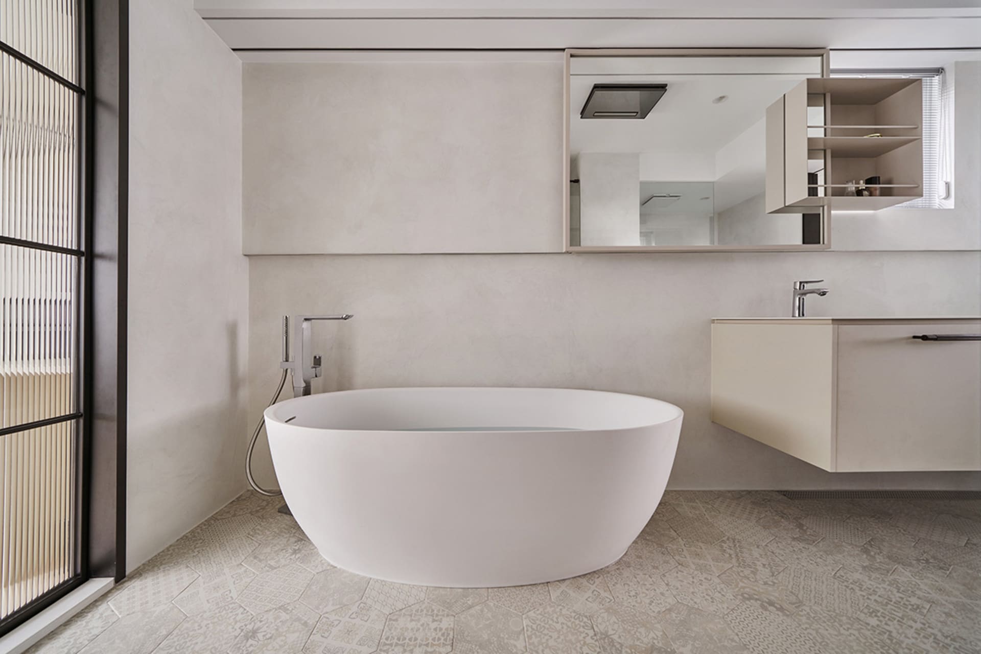 A modern minimalist bathroom with a freestanding bathtub, concrete walls, and floor tiles.