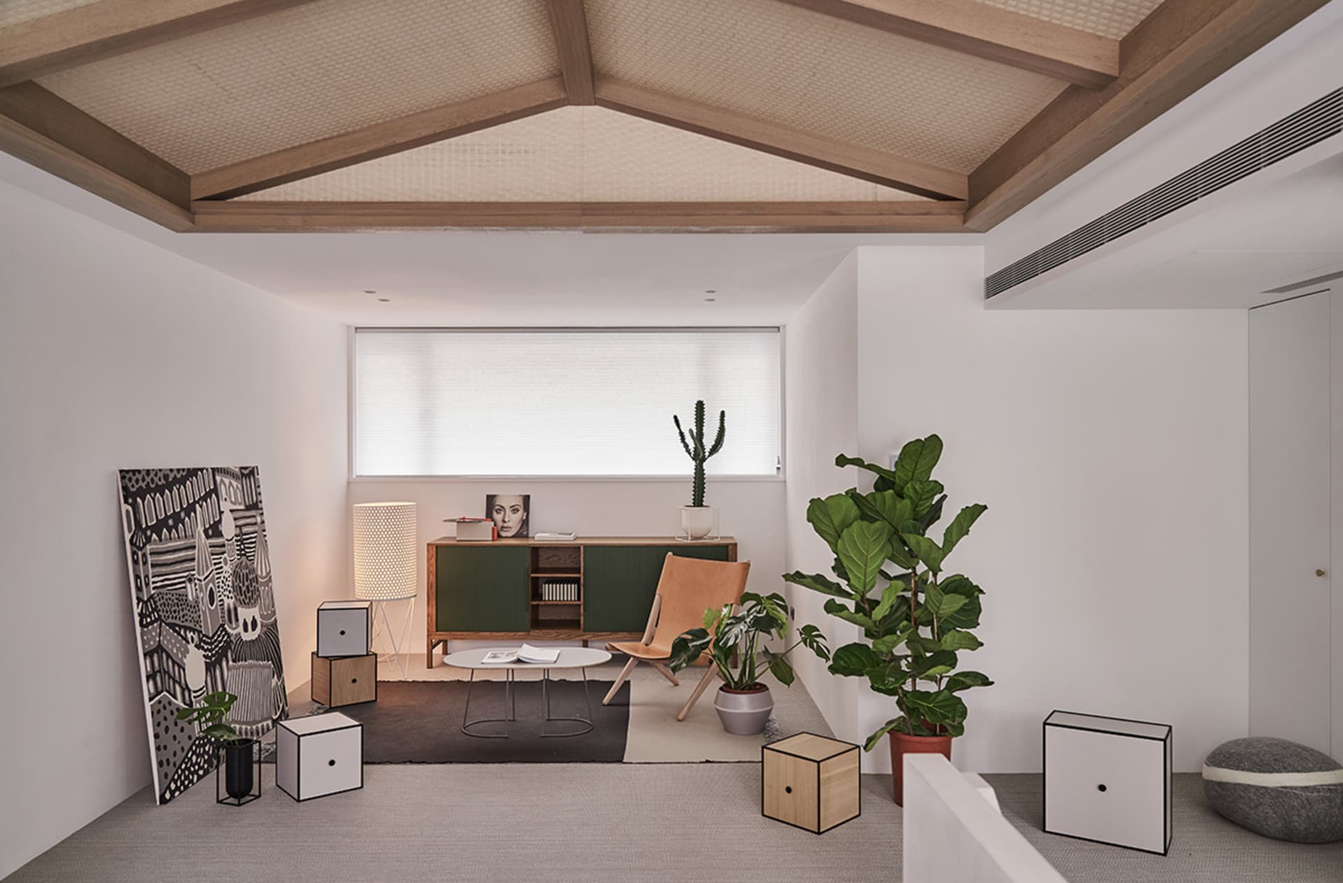 A modern living room featuring wooden furniture, plants, and decorative elements.