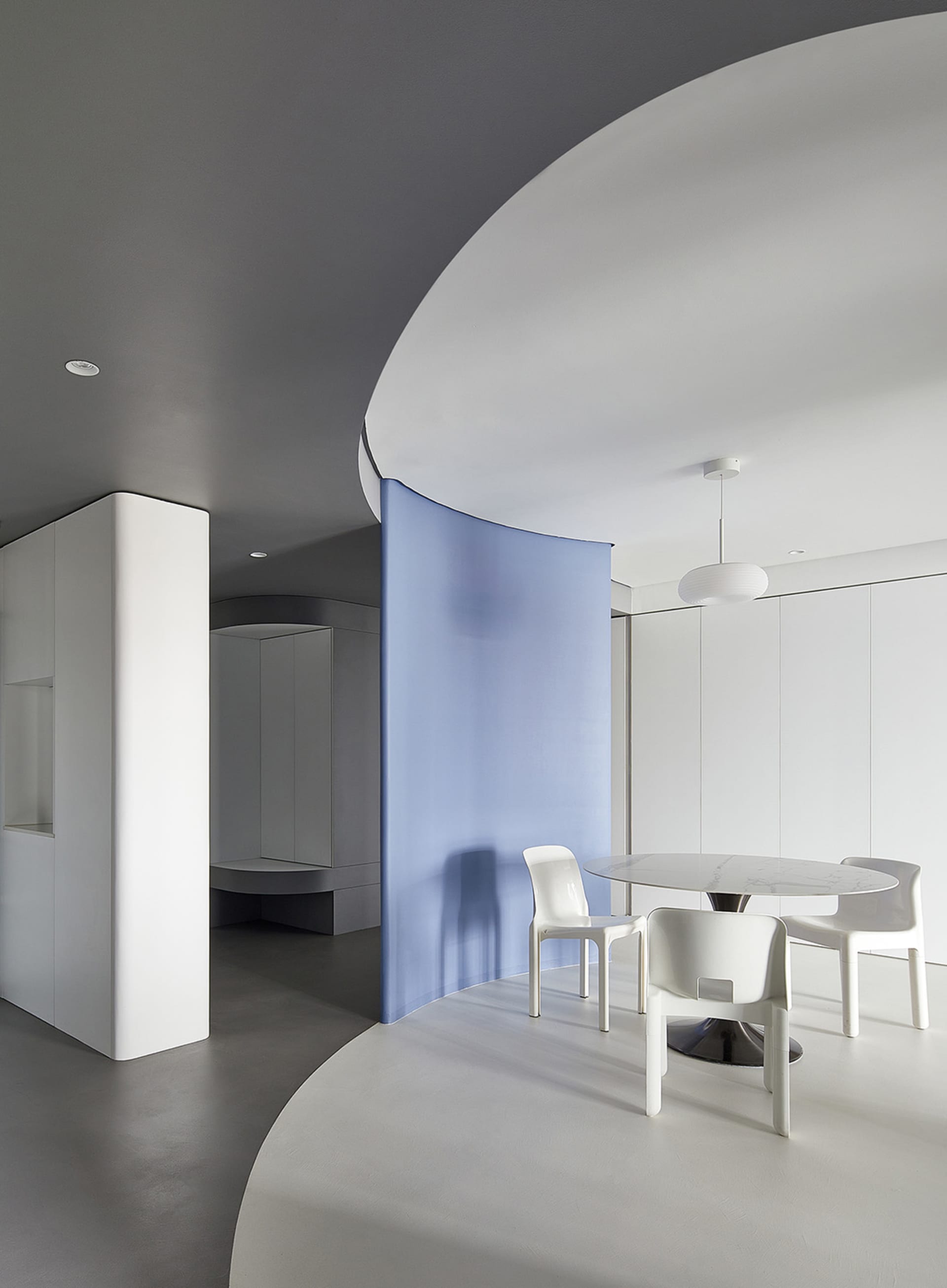 Modern minimalist interior design featuring polished concrete, white plaster walls, and glass elements.