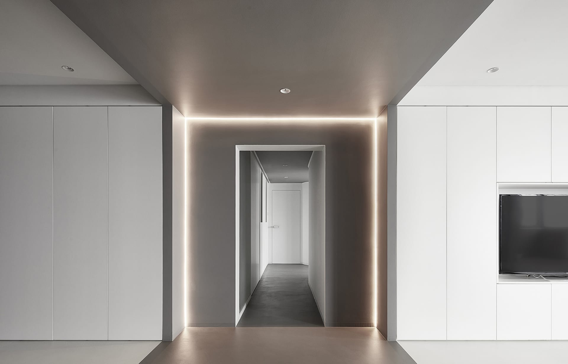 A modern, minimalist interior design featuring a concrete floor and white walls.