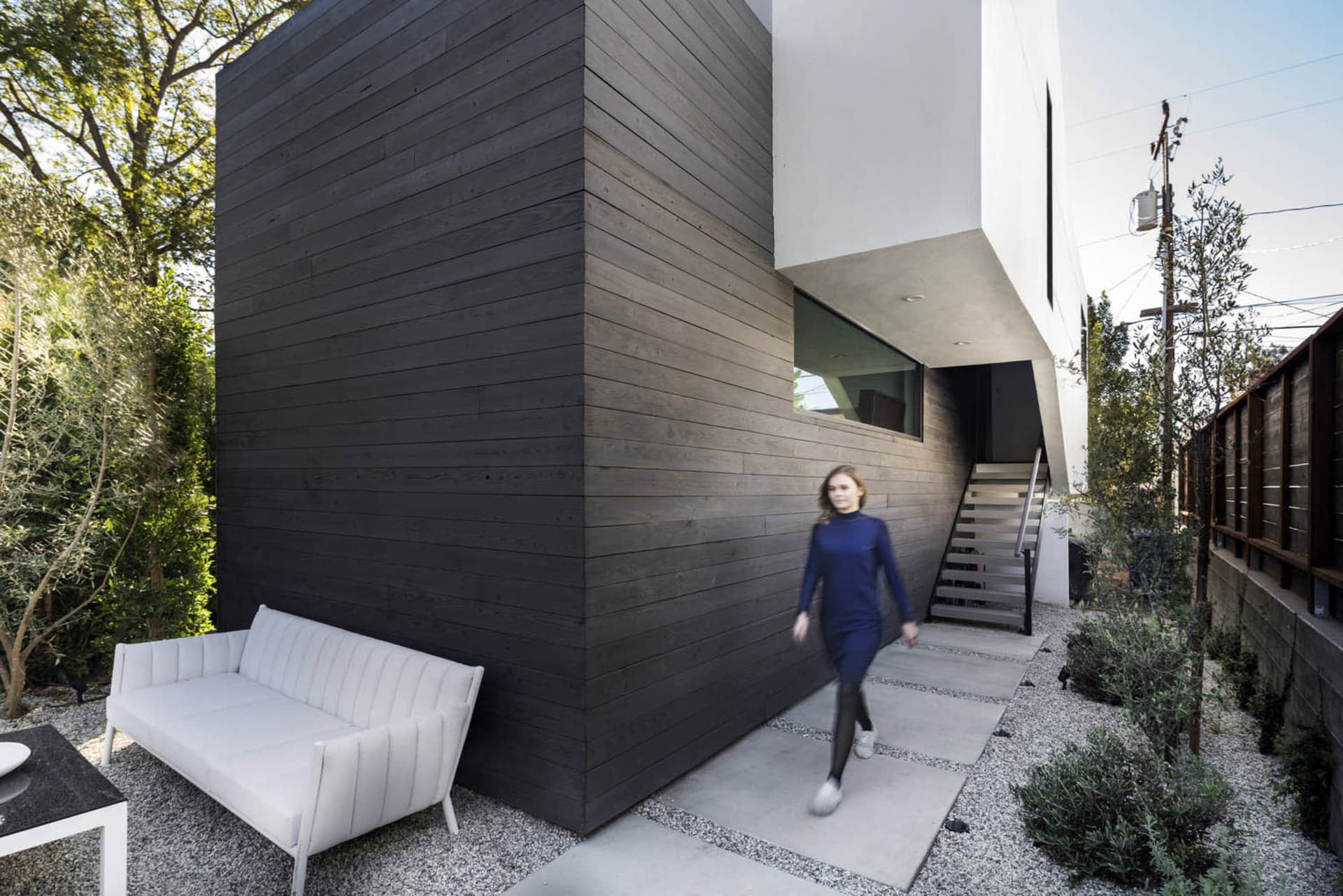 A modern residential exterior featuring concrete and wood materials.