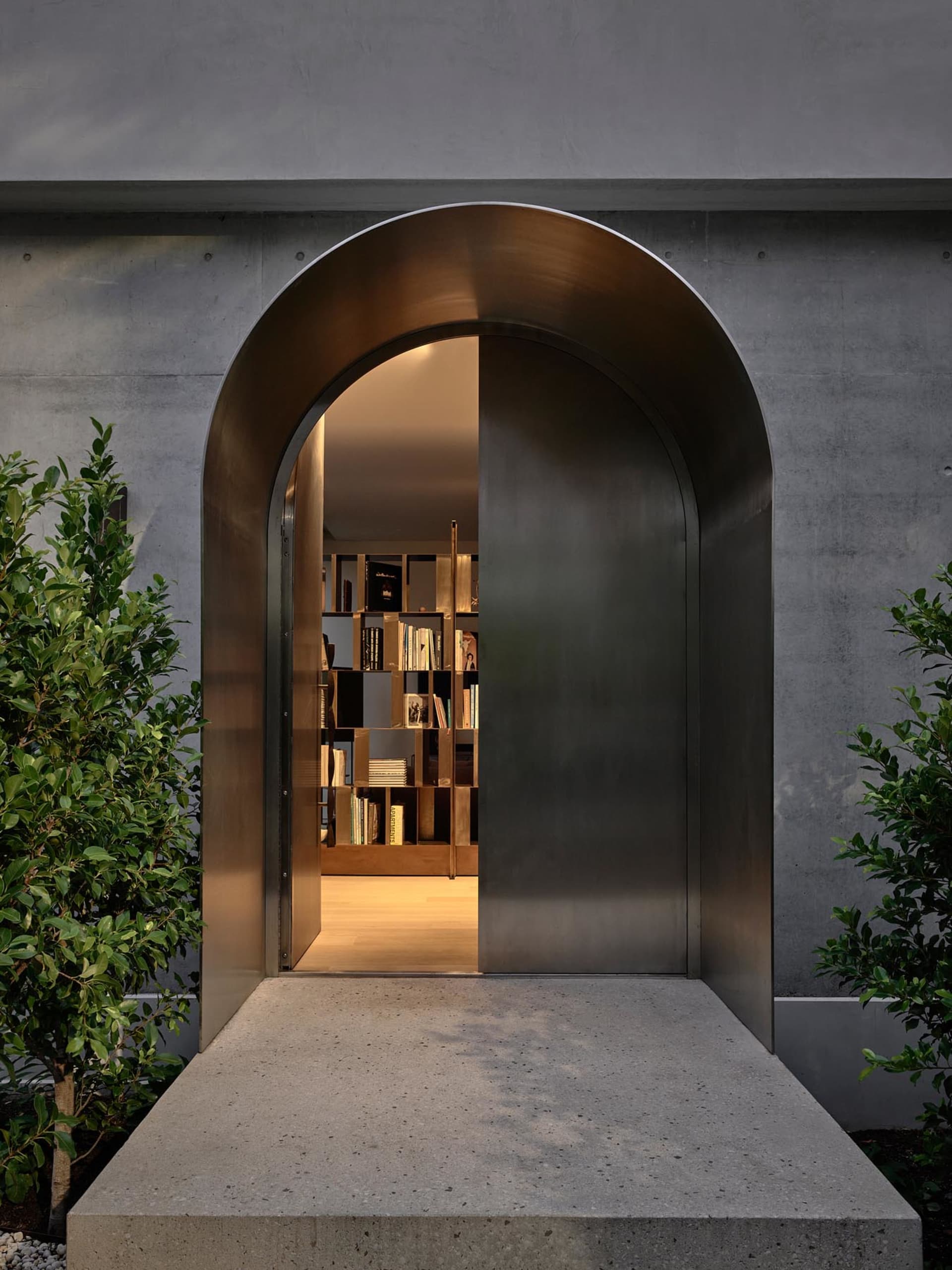 An arched metallic entranceway leading into a space filled with books.
