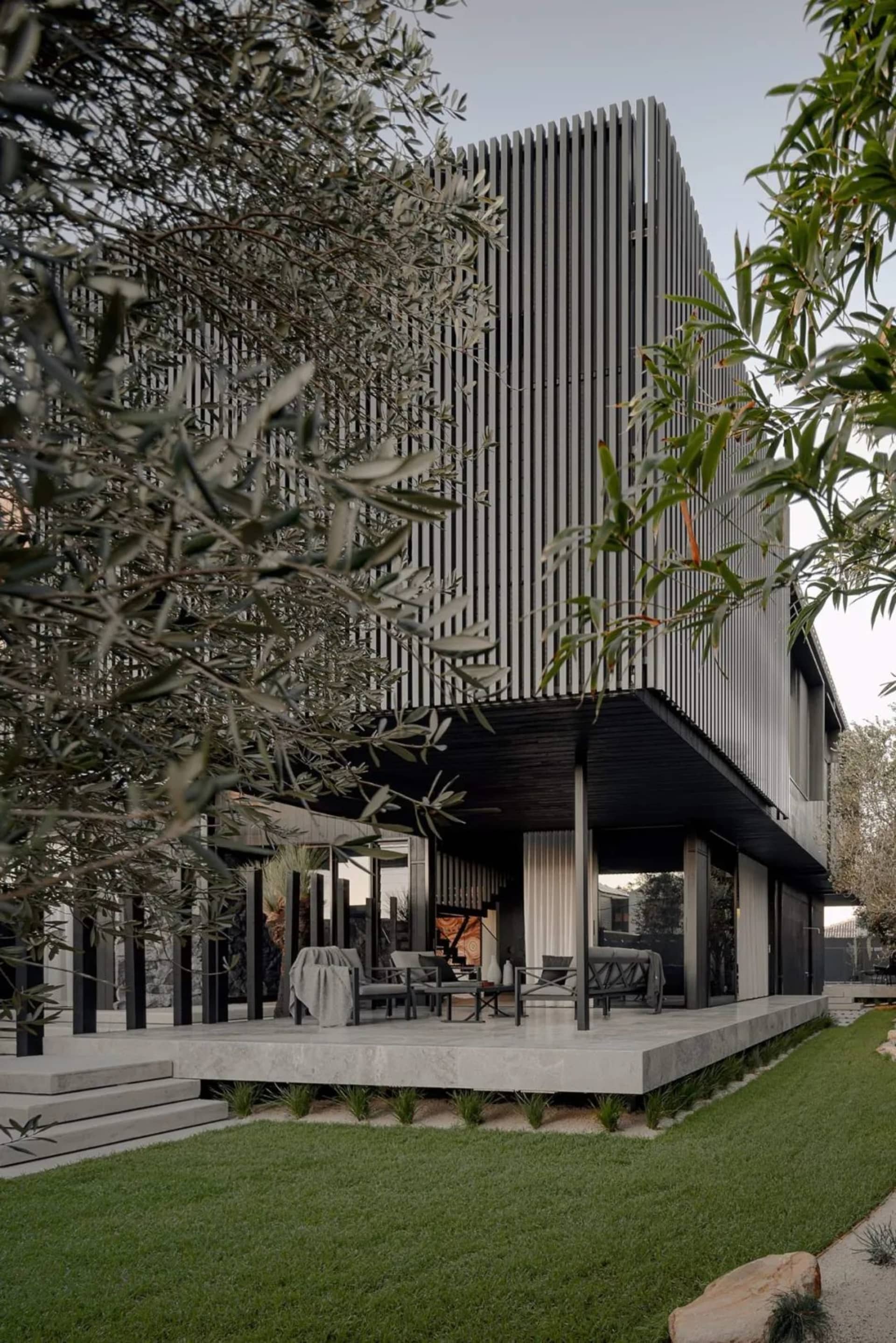 Modern residential exterior with metallic vertical elements and wood accents.