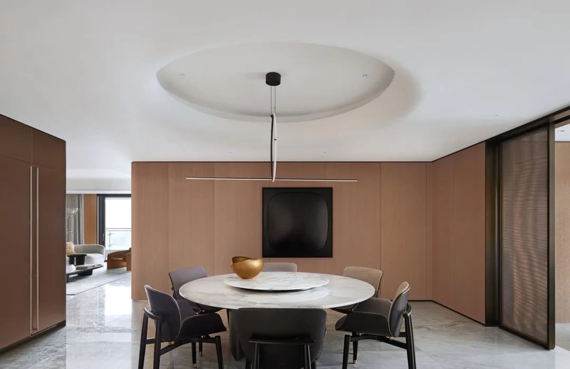 Modern minimalist dining room with a marble table and wood walls.