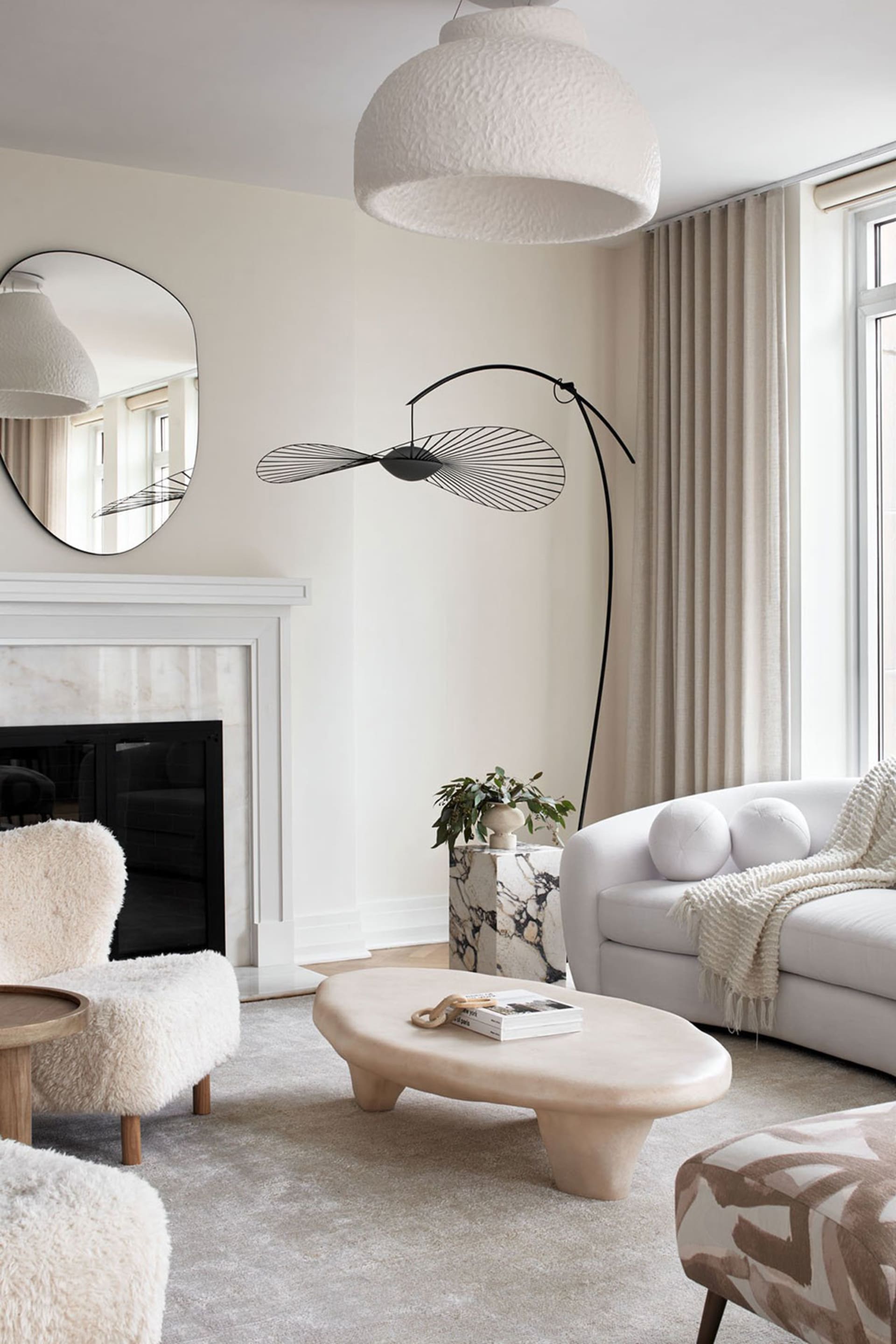 A modern living room featuring marble furniture and upholstered fabric seating.