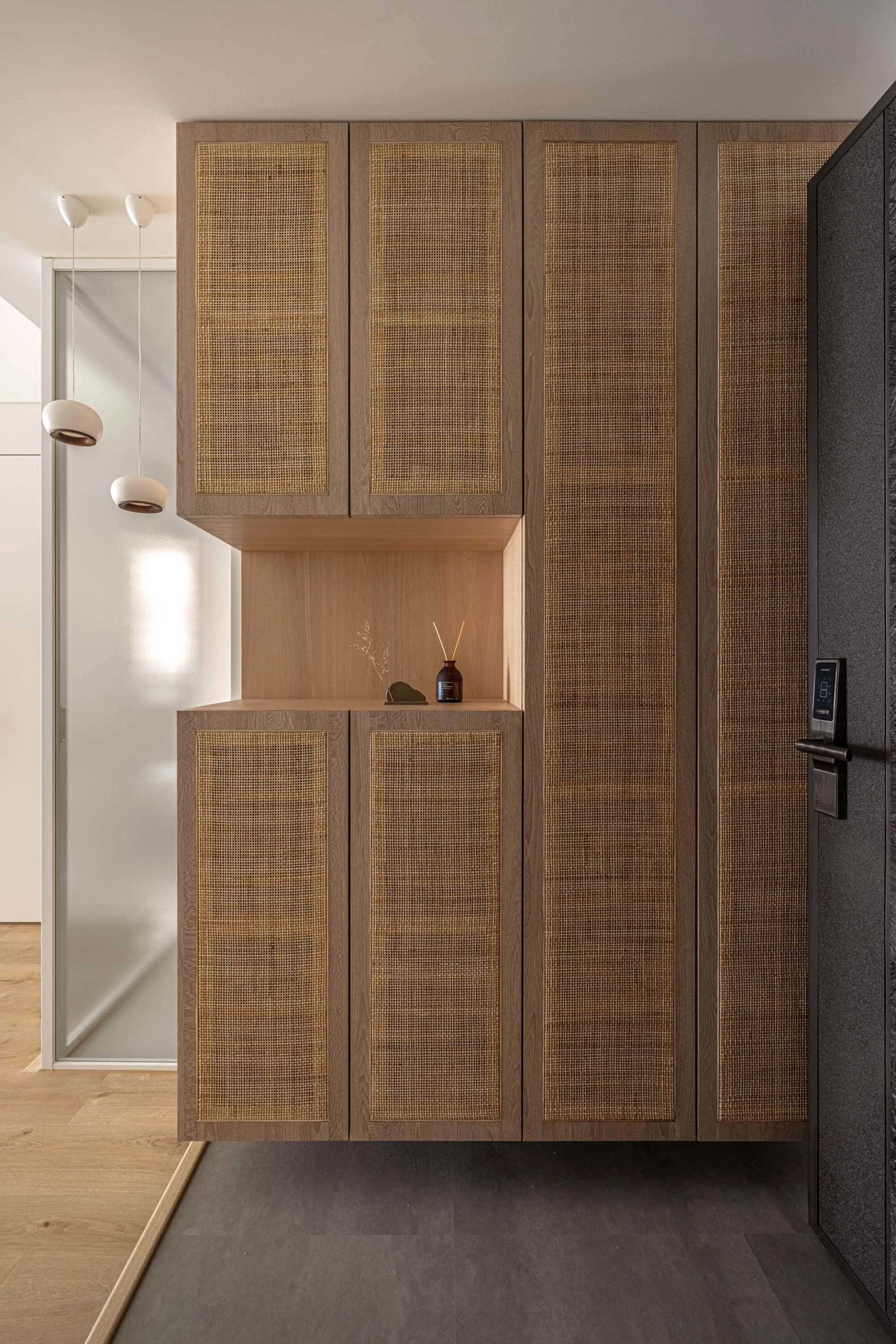 Modern interior entryway featuring a combination of wood and cane material for storage