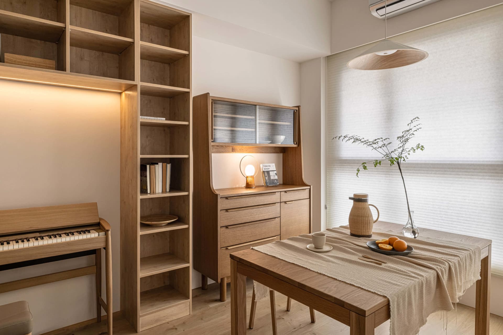 A cozy modern living room with wooden furniture, a table, and a bookshelf.
