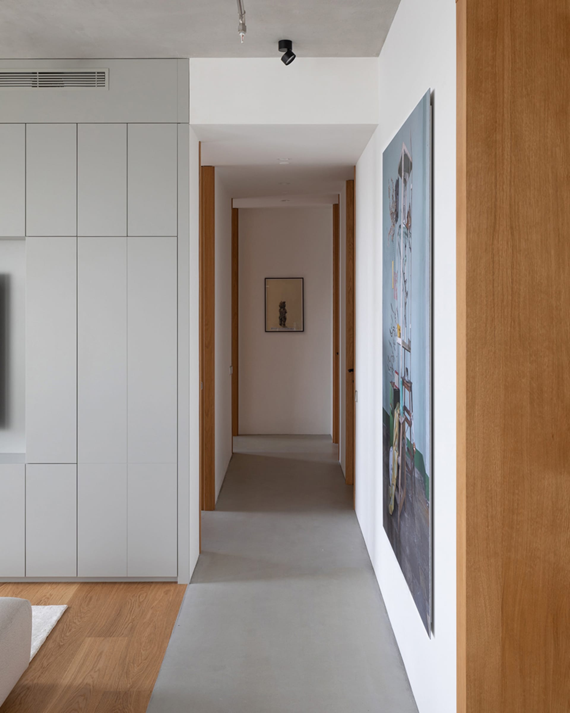Modern minimalist interior design featuring concrete flooring and wooden elements.