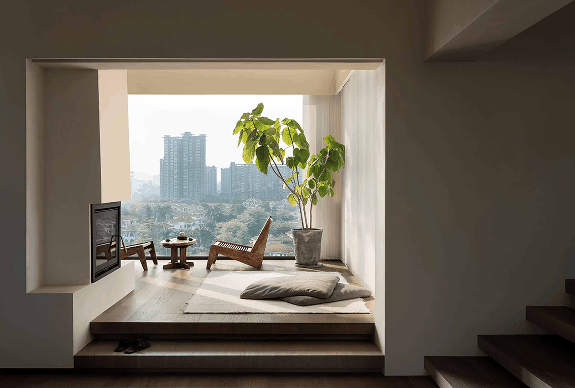 A minimalist living room with a modern design featuring wood furniture, concrete flooring, and large windows.