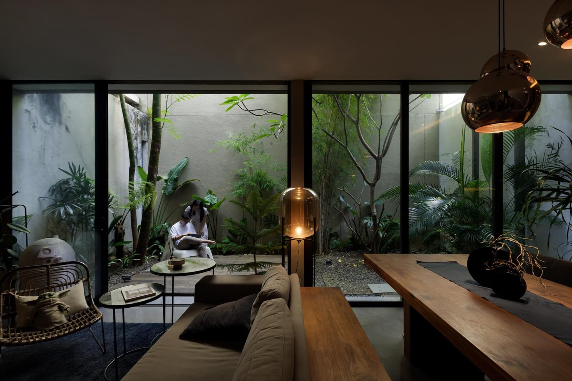 A modern minimalist home interior with a mix of materials like wood, concrete, and glass, featuring a cozy seating area and a