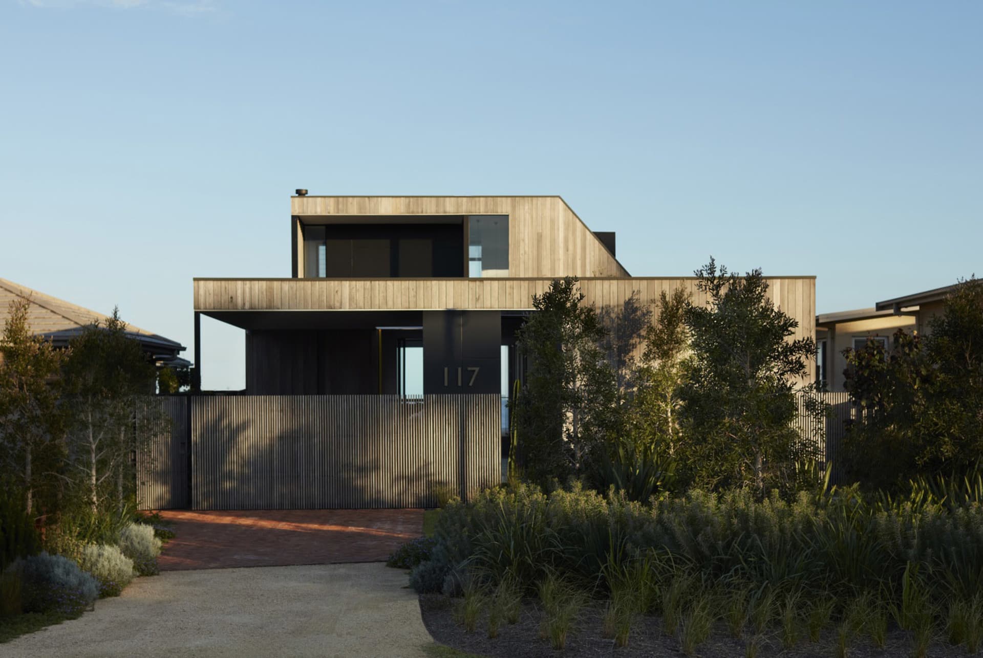 Modern residential home with wooden exterior on a clear day.