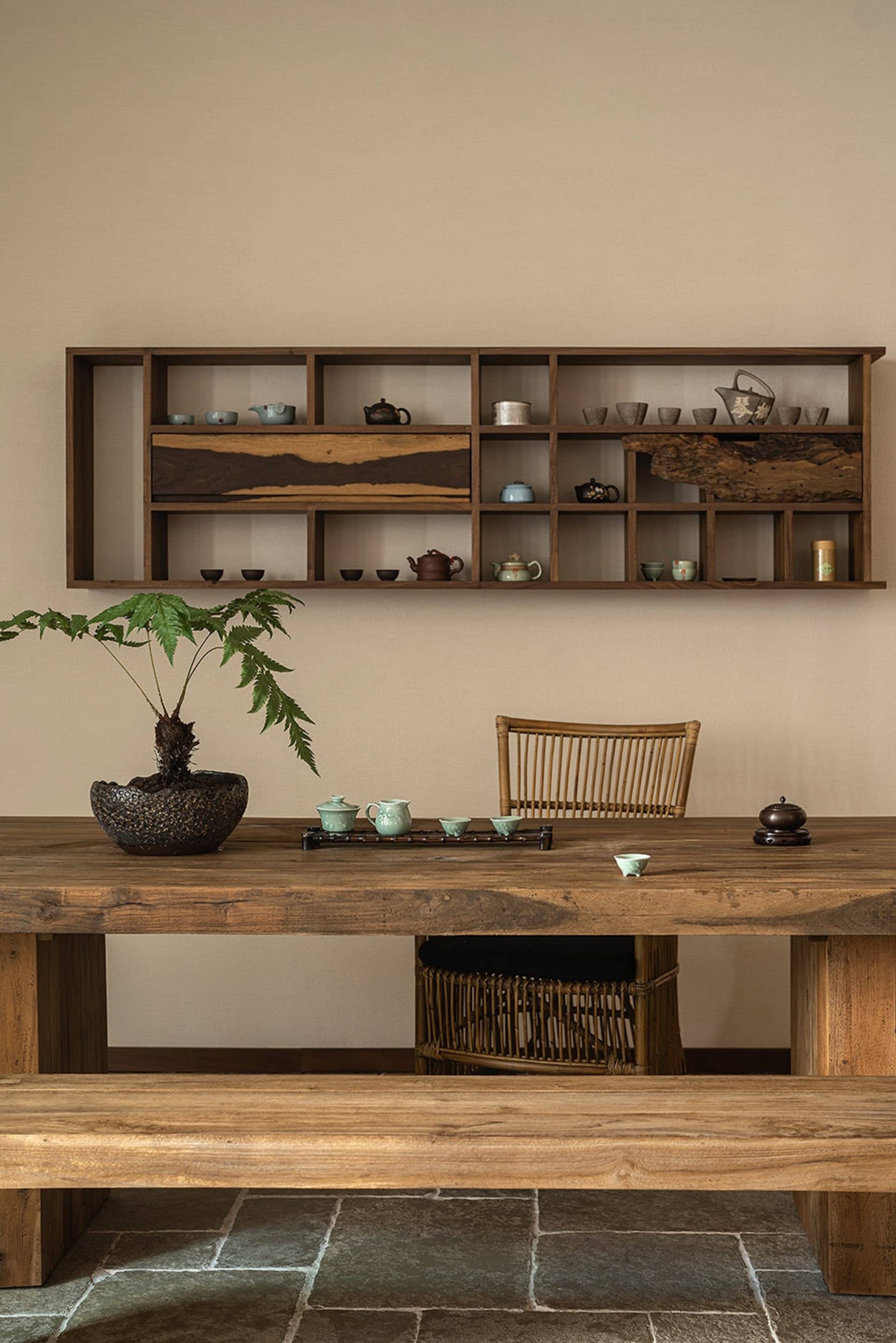 A tea room featuring wooden furniture and a shelf with various tea pots.