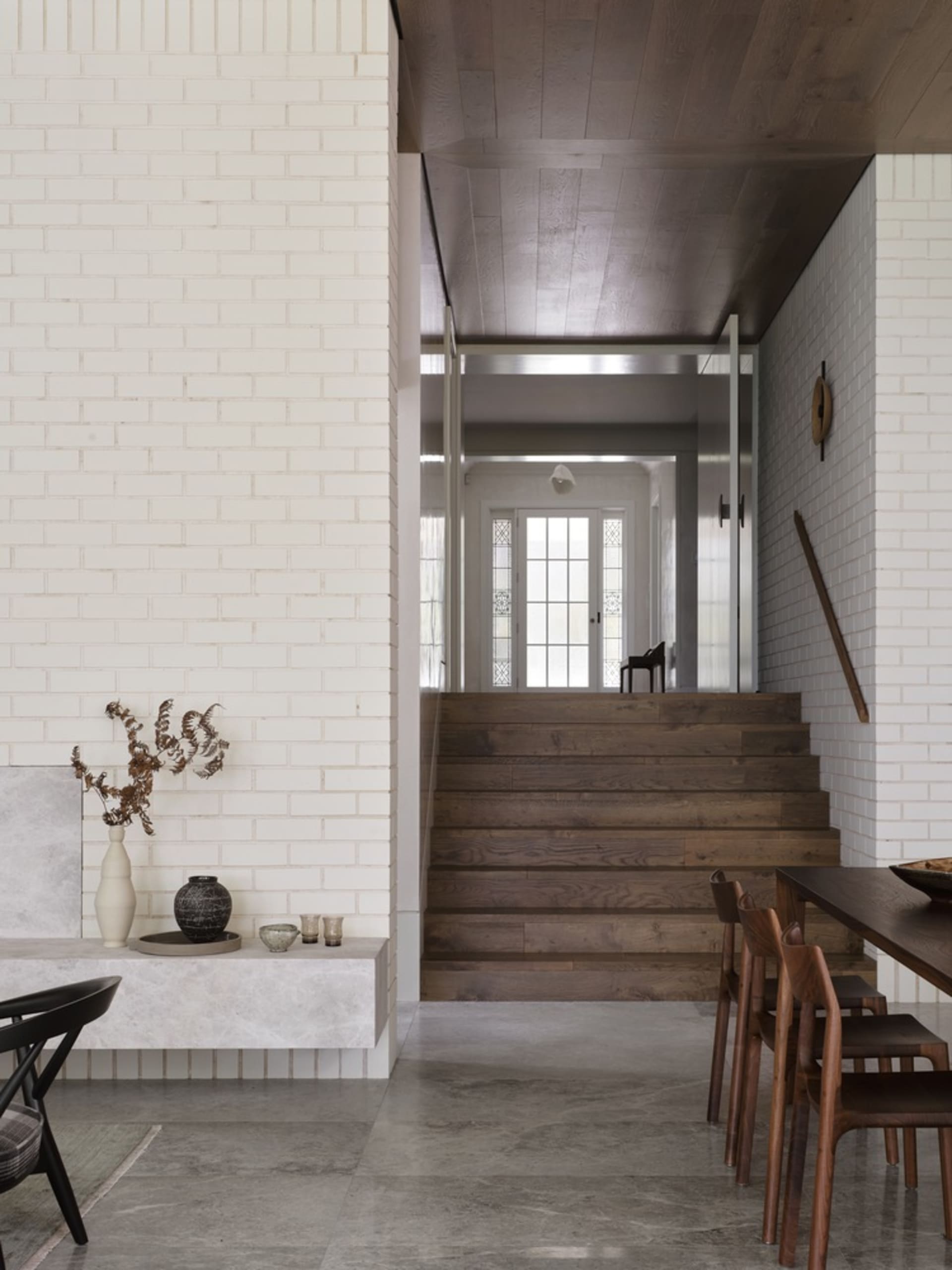 Modern interior design featuring wood, concrete, and brick surfaces.