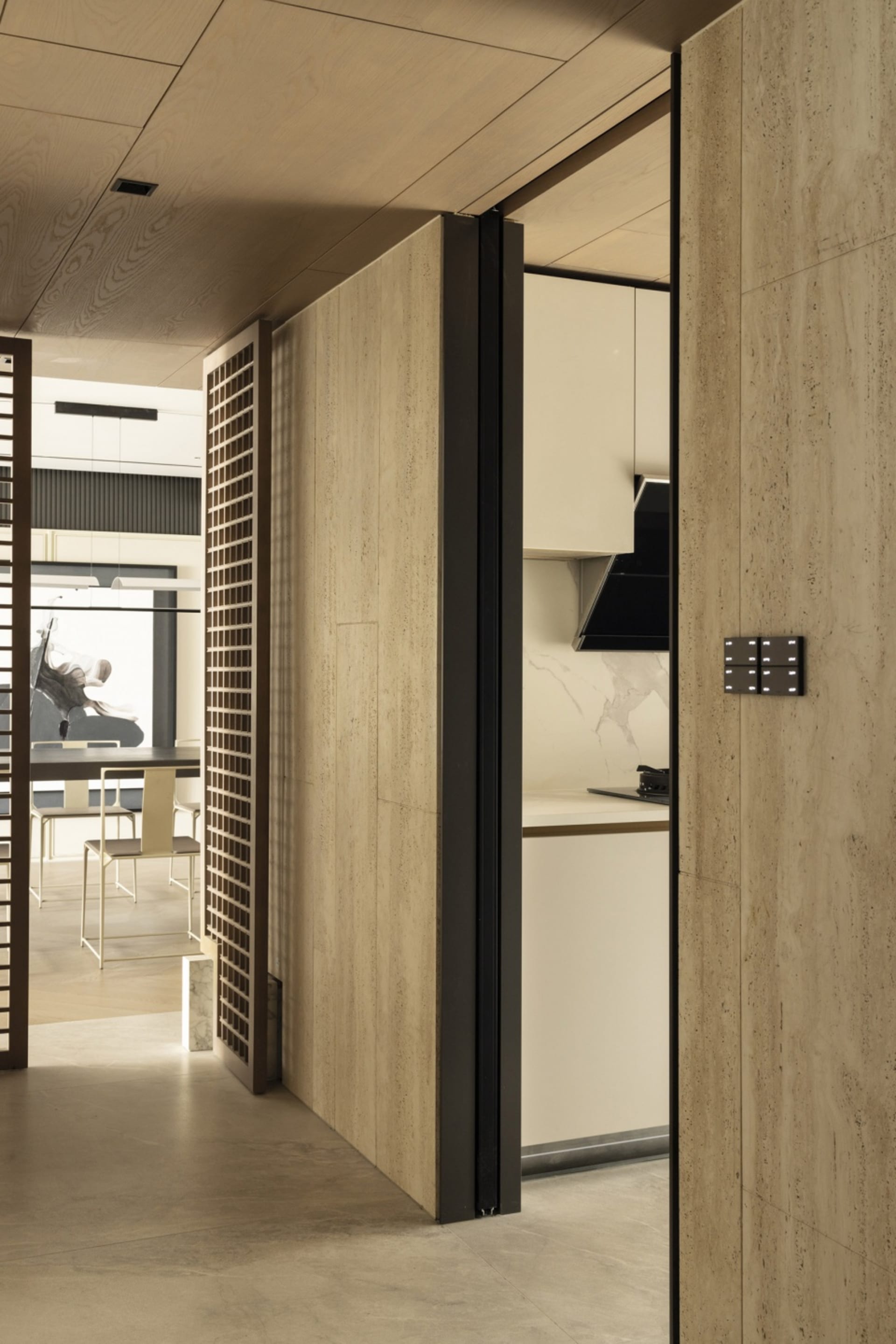 A modern minimalist kitchen with an open-concept layout, showcasing sleek, light-colored wooden cabinetry and a smooth, conti