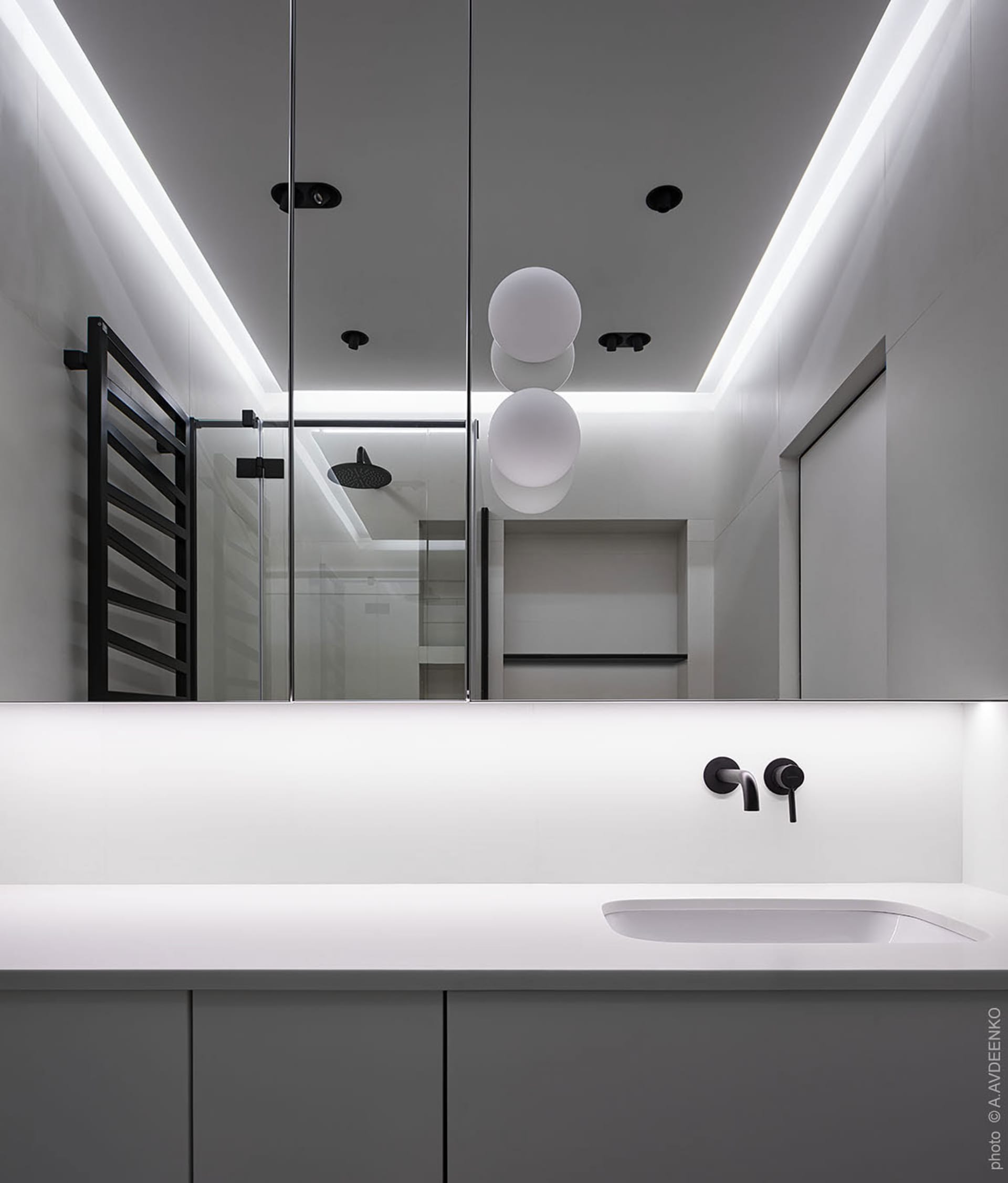 A modern minimalist white bathroom with sleek lines and a neutral color palette.