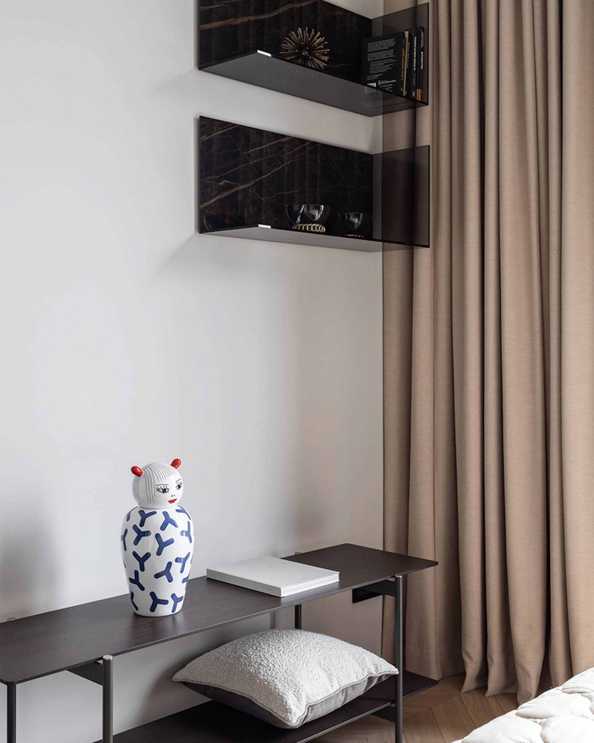 A minimalist bedroom featuring glass and marble decor elements.